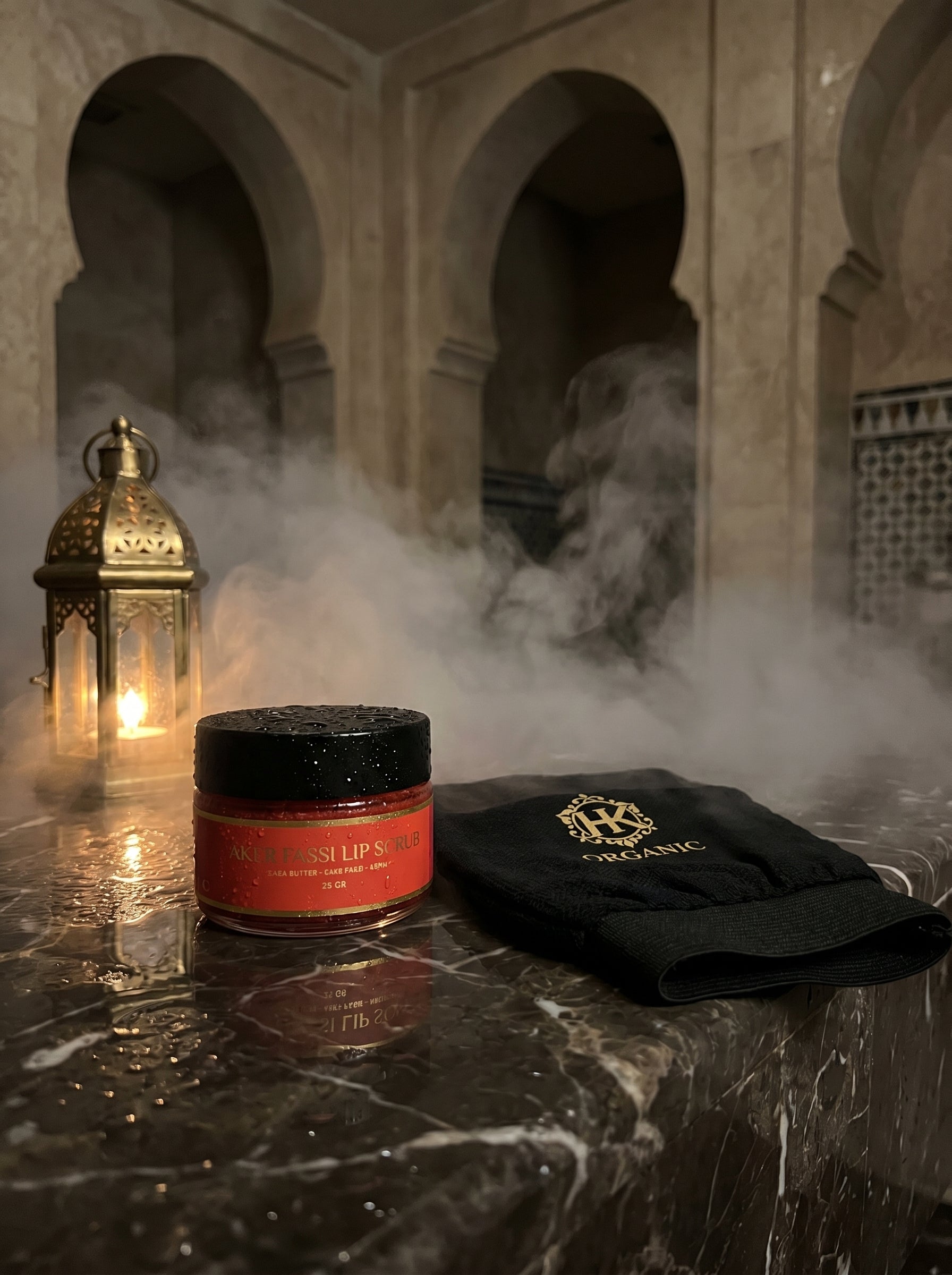 Jar of lip balm and black towel on a marble surface with a lantern and smoke in the background
