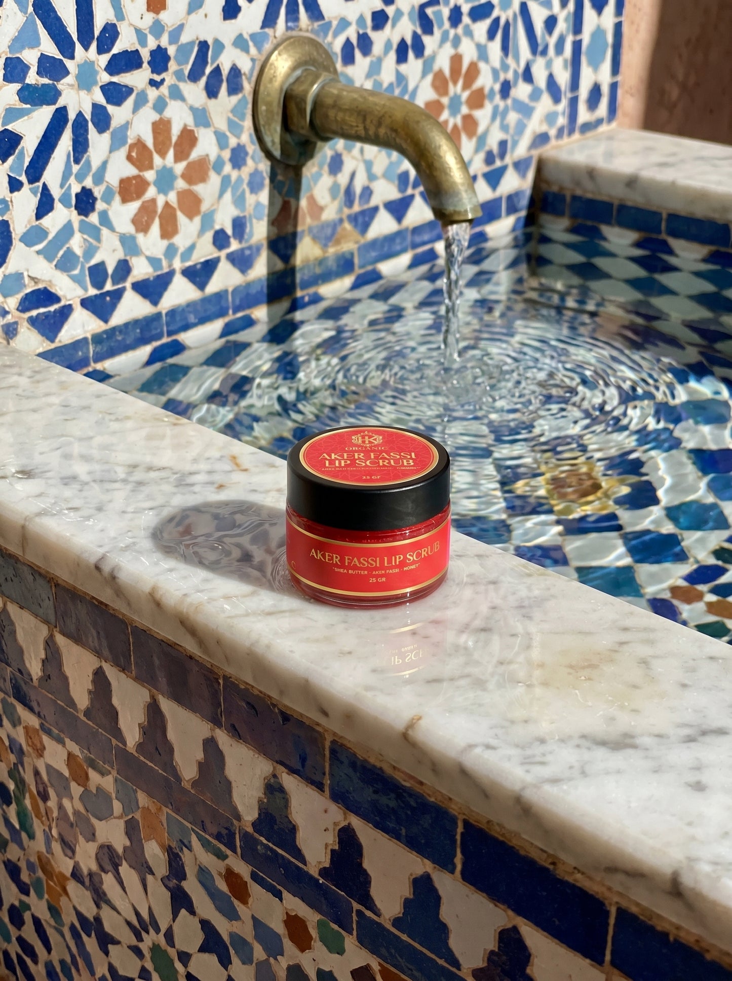 Red jar on a marble countertop with mosaic tile backsplash