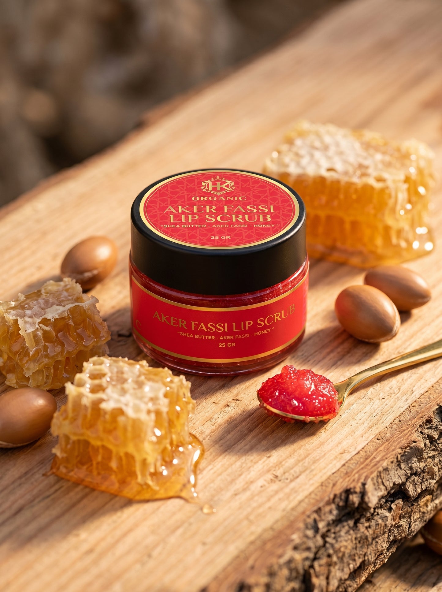 Aker Fassi lip scrub jar with honeycomb and almonds on a wooden surface