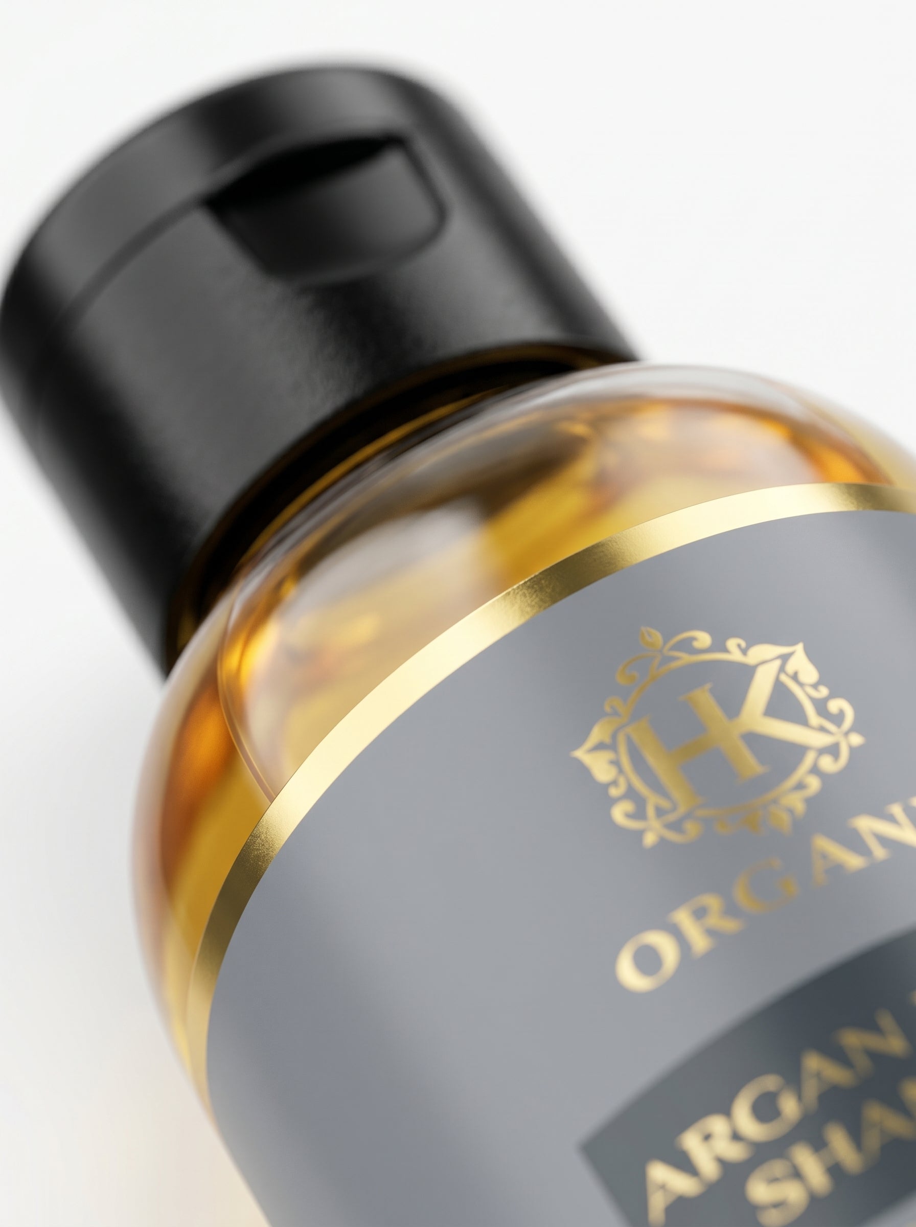 Bottle of argan oil with a gold cap on a white background