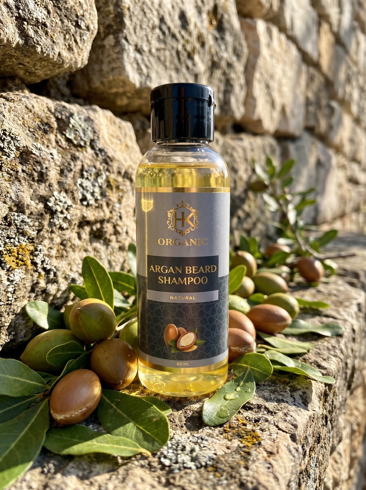 Bottle of argan beard shampoo with argan nuts and leaves on a stone background