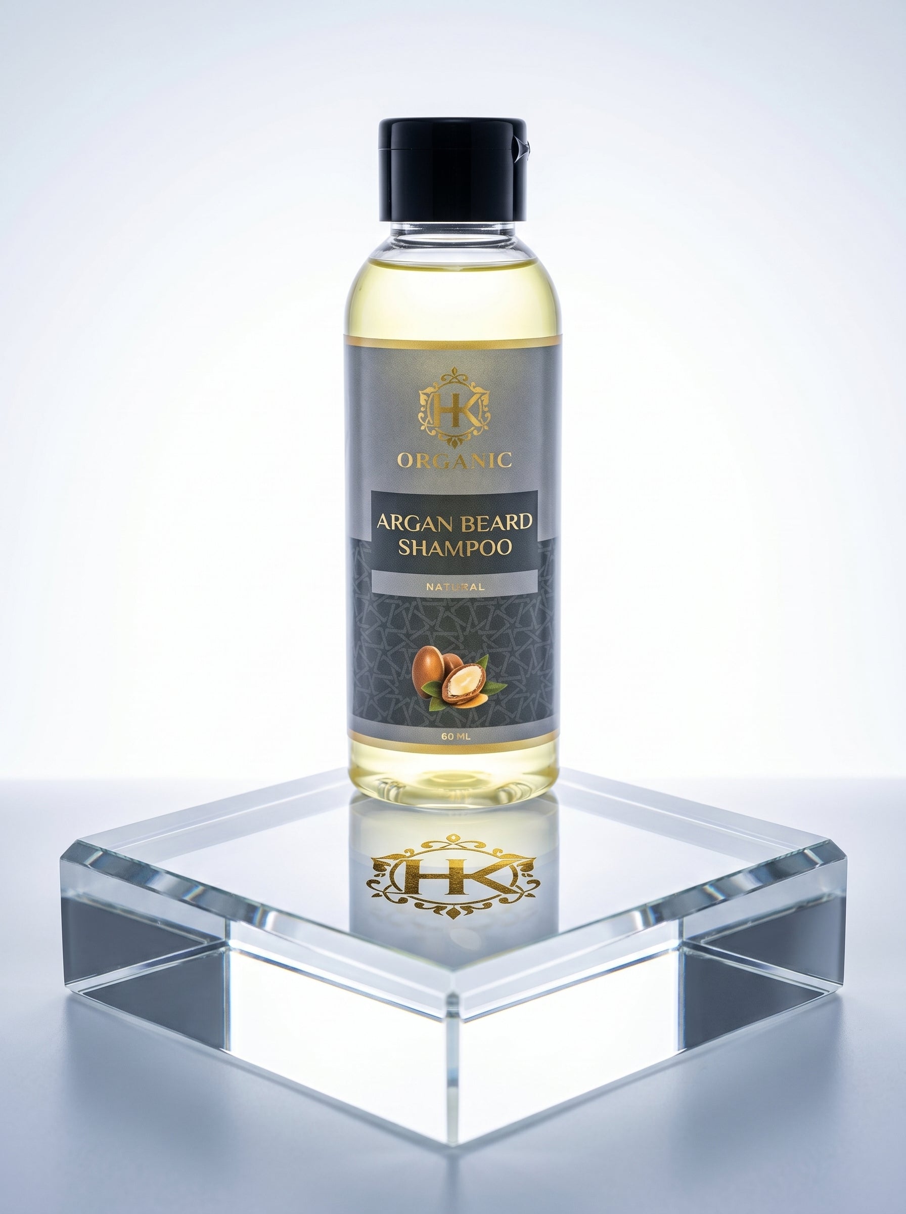 Bottle of argan beard shampoo on a reflective surface with a light gray background