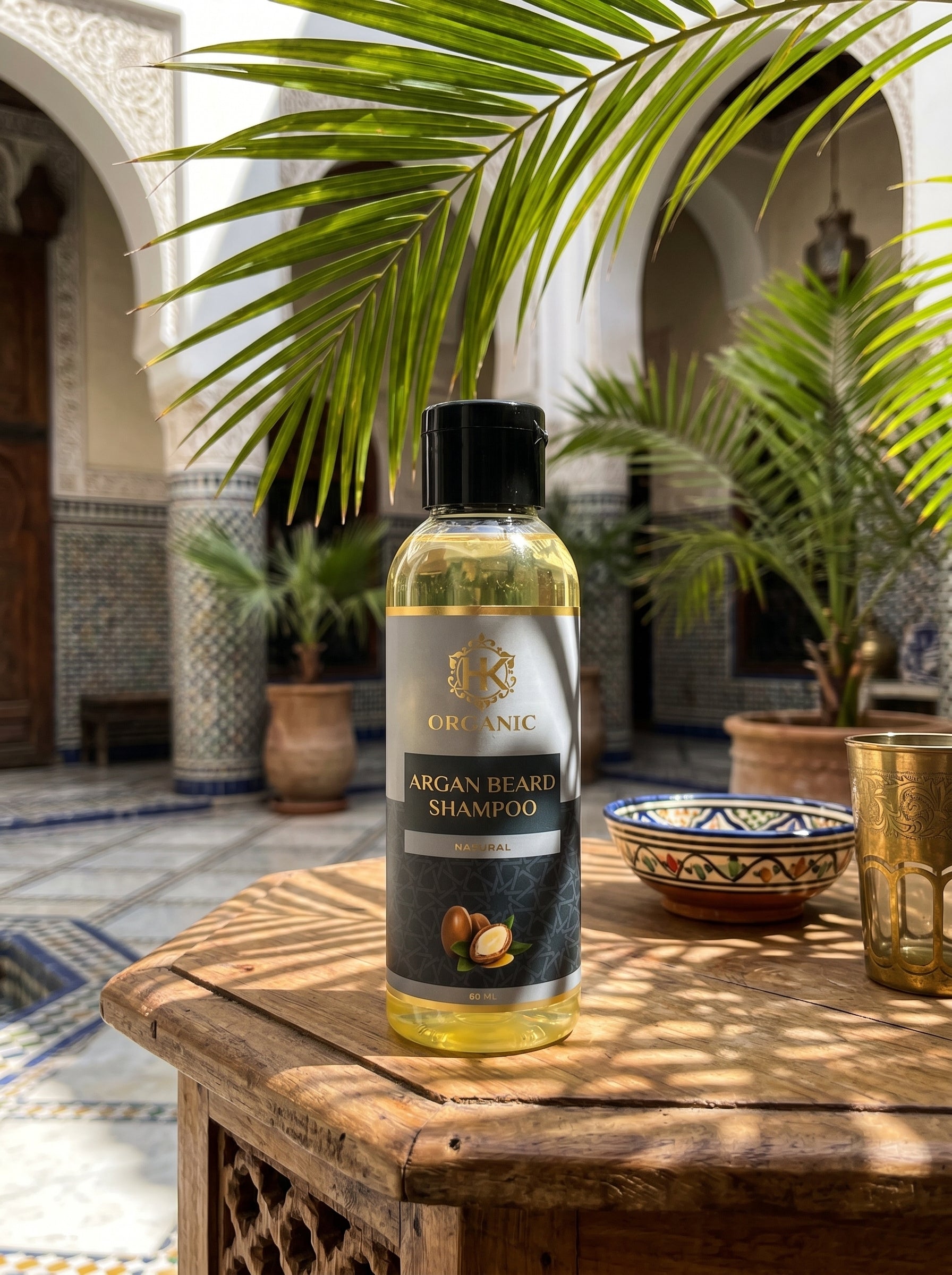 Bottle of argan beard shampoo on a wooden table with a decorative background