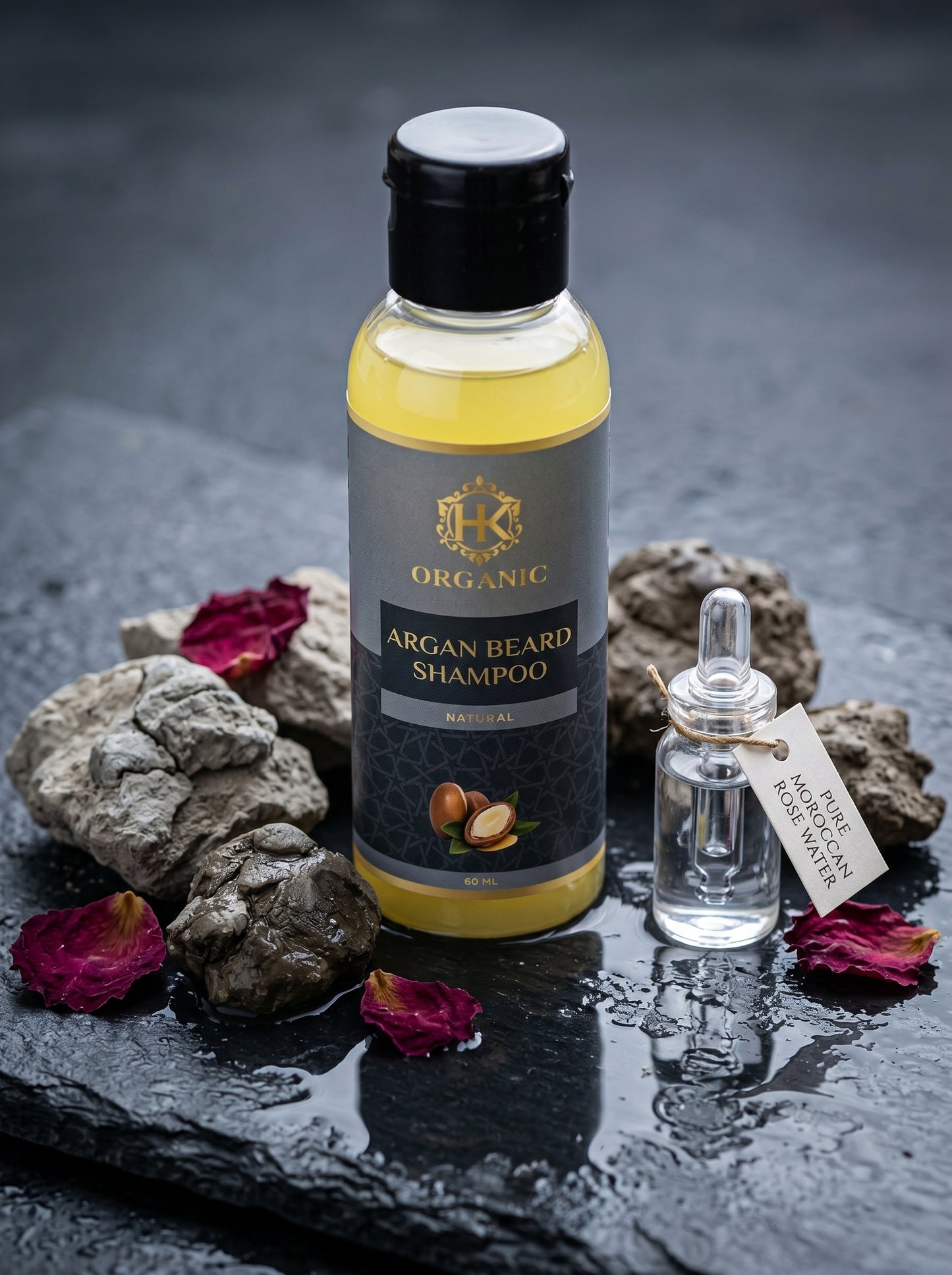 Organic argan beard shampoo bottle with a dropper on a dark stone surface with flowers.