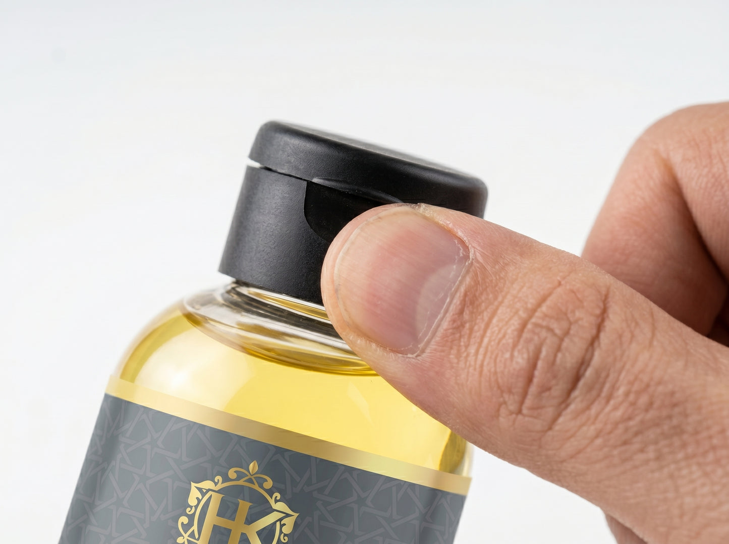 Hand holding a bottle of HK skincare product with a focus on the cap.