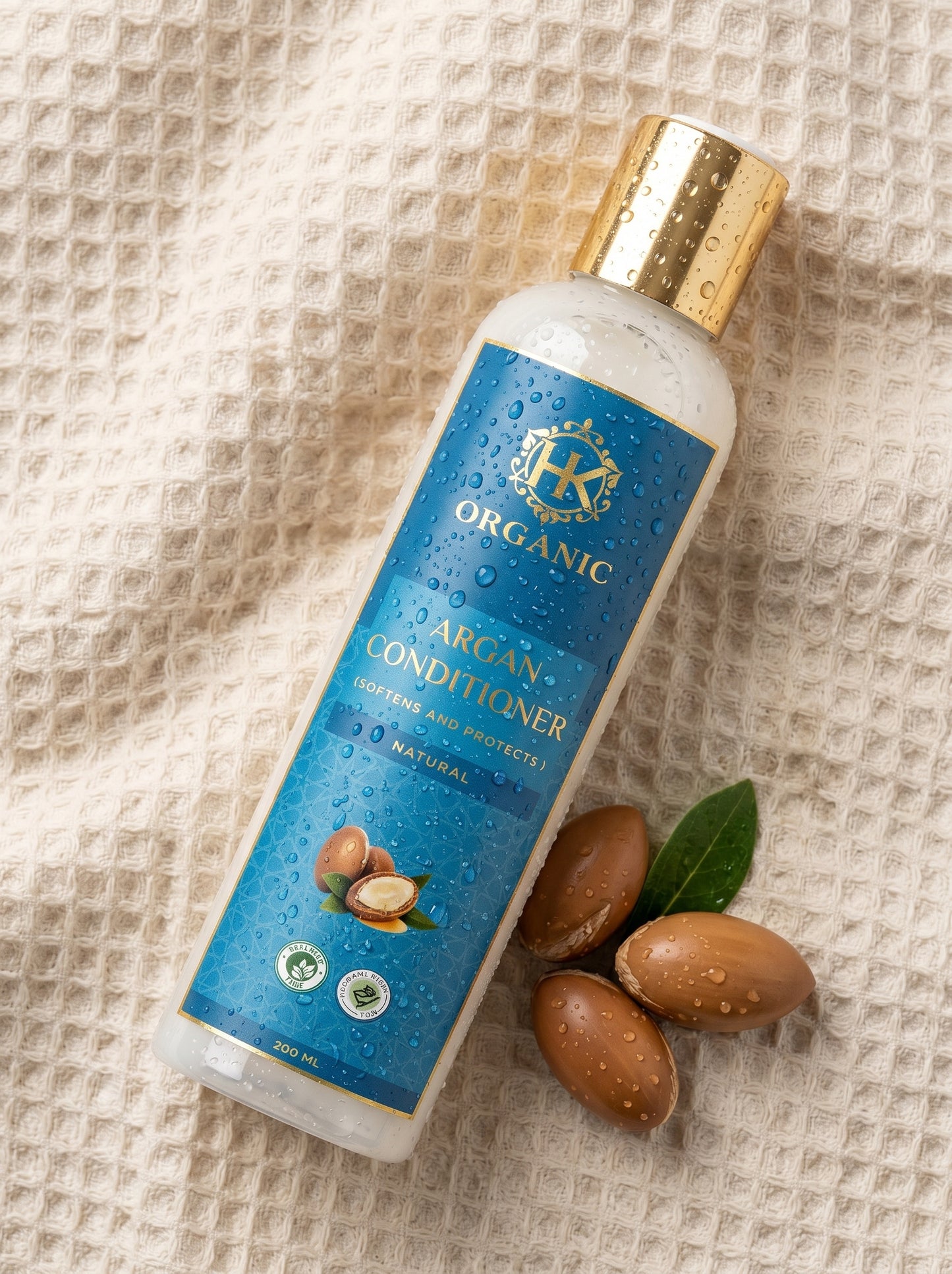 Argan conditioner bottle with nuts and leaves on a textured fabric background