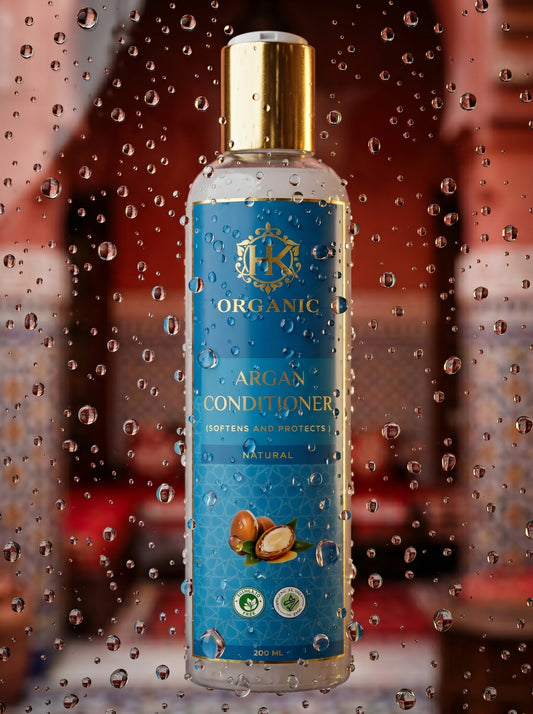 Bottle of organic argan conditioner with a blue label on a wet surface
