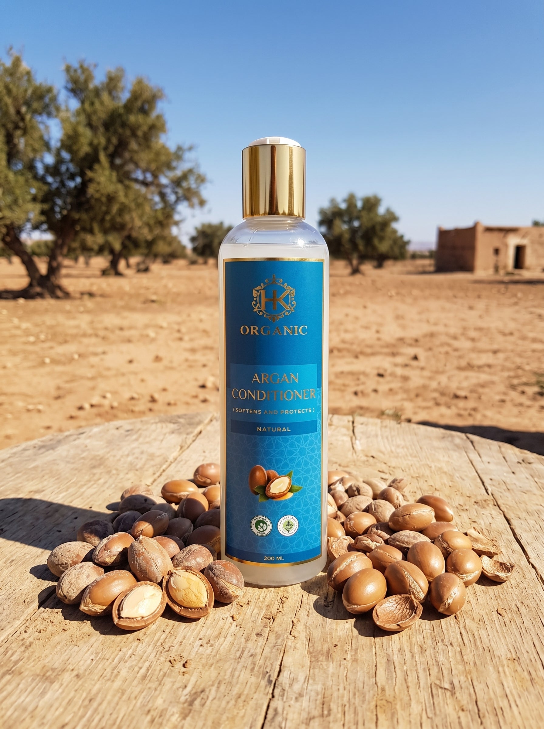 Bottle of argan conditioner with argan nuts on a wooden surface with a desert landscape in the background
