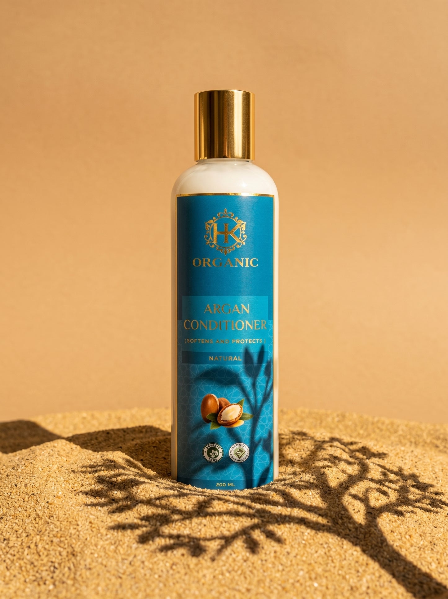 Bottle of Argan Conditioner with a gold cap on a beige background