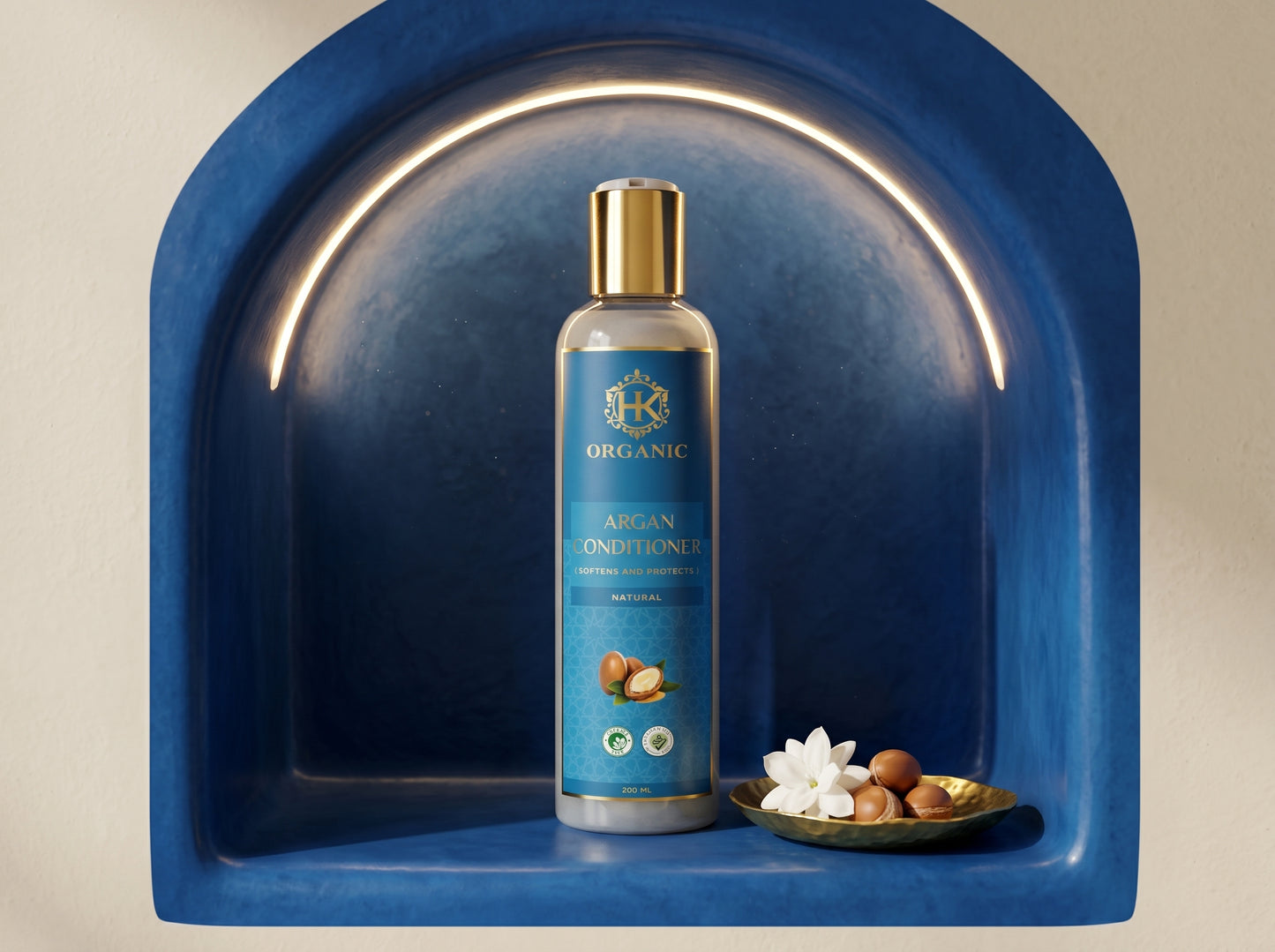 Blue bottle of organic argan oil with nuts and flowers on a beige background