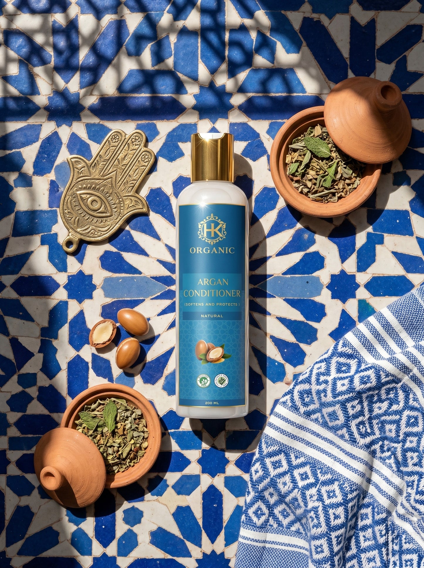Organic argan conditioner bottle on a blue and white patterned surface with decorative items.