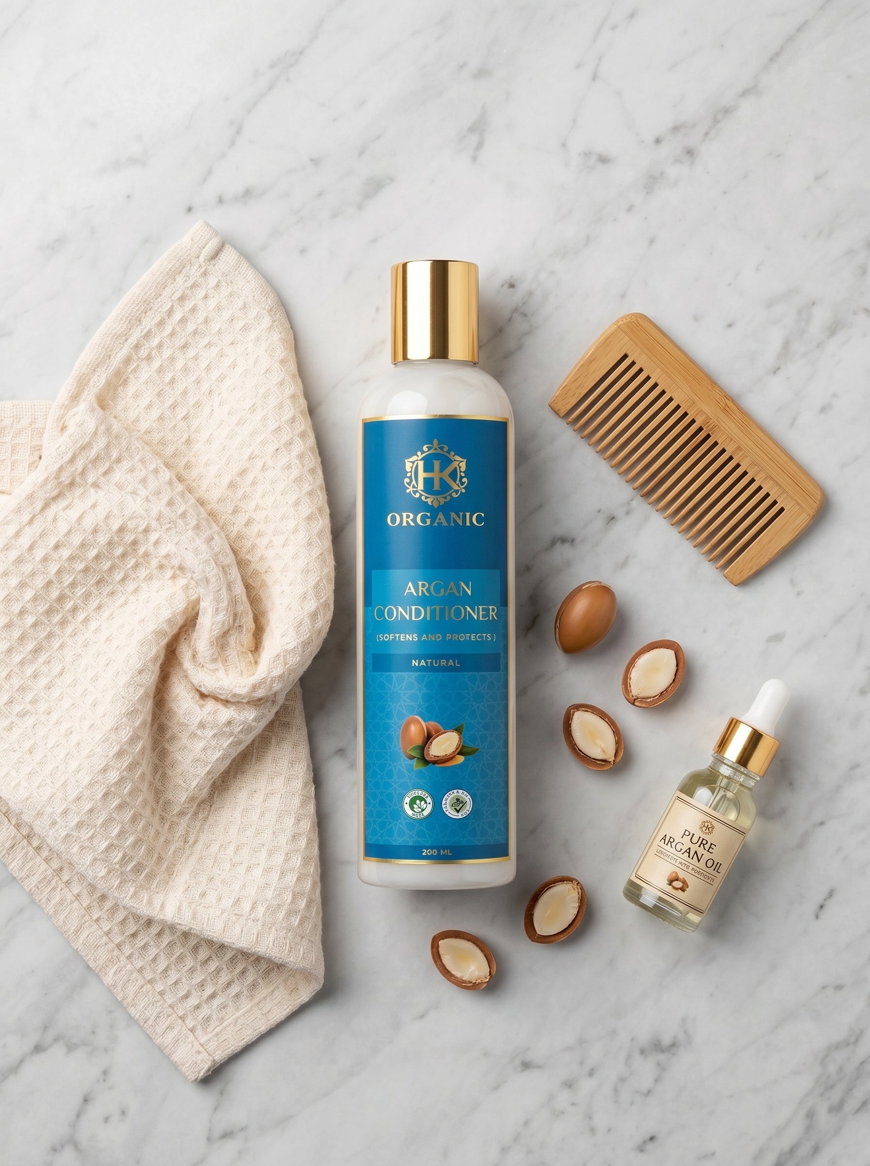 Organic argan conditioner bottle with a towel, comb, and argan oil on a marble surface