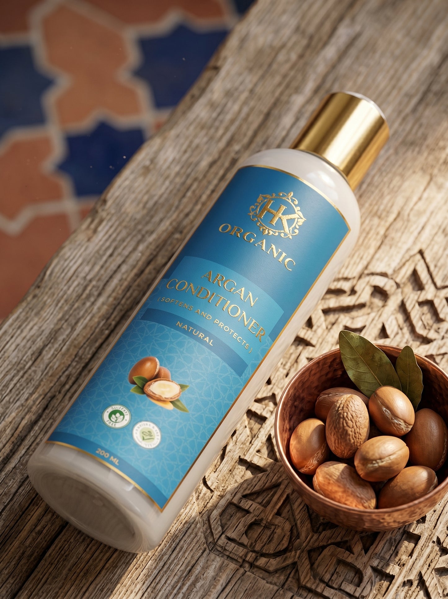 Bottle of organic argan conditioner with a bowl of argan nuts on a wooden surface.