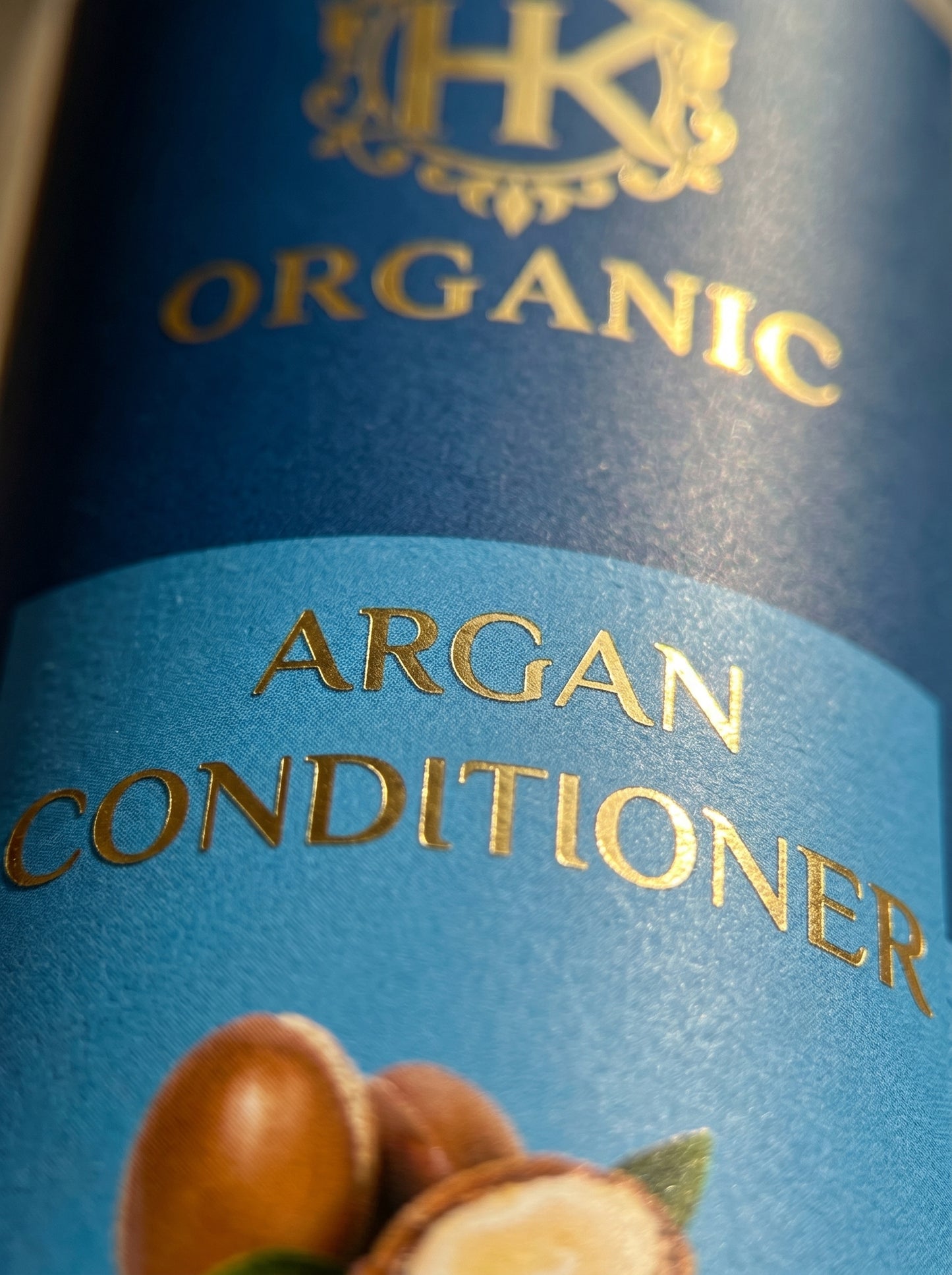 Close-up of a bottle label for organic argan conditioner with a logo and text.