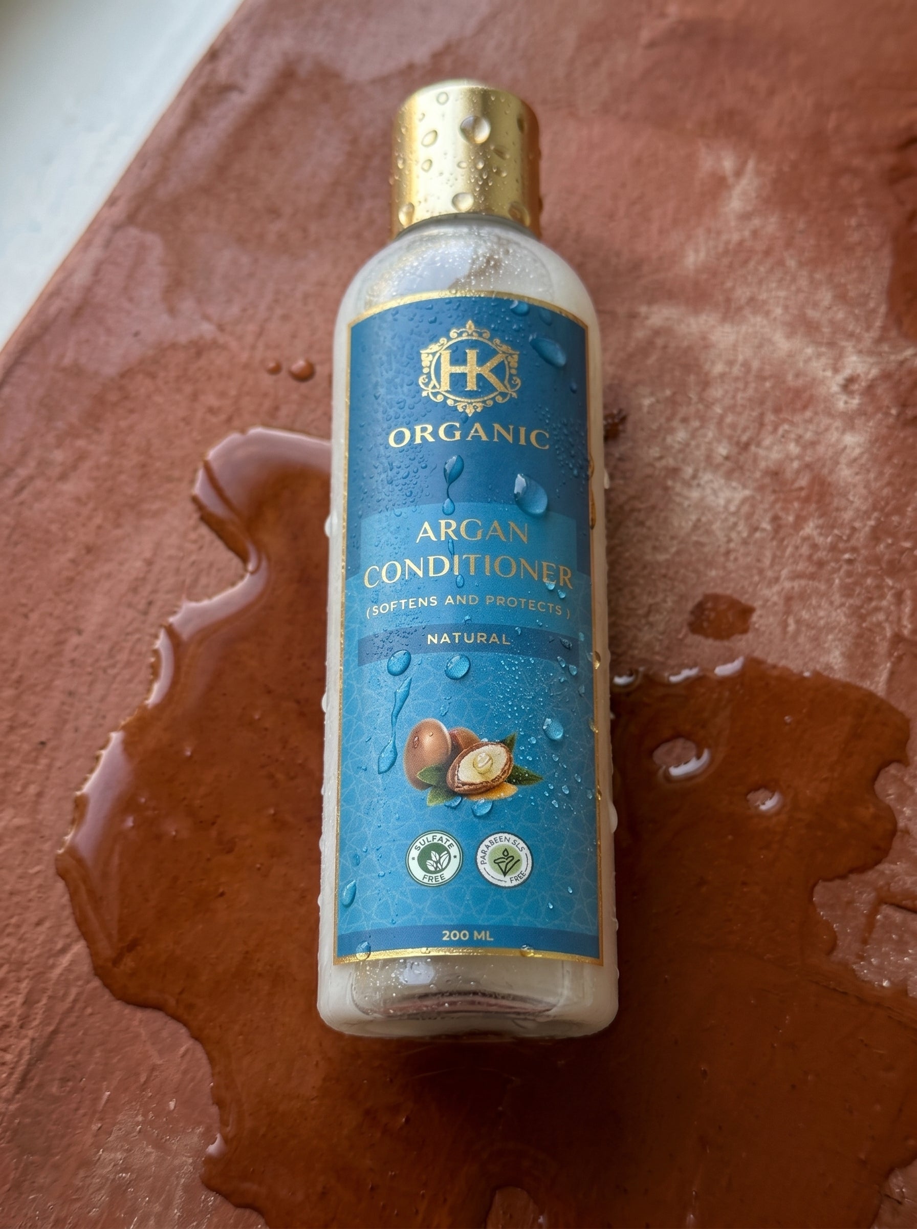 Bottle of organic argan conditioner on a textured surface