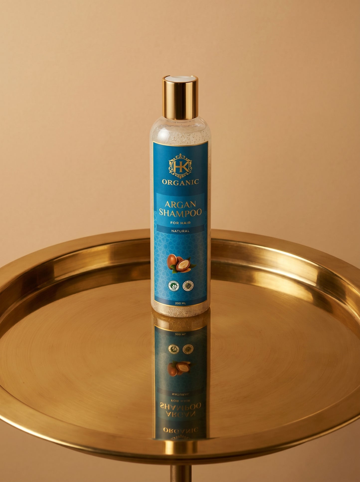 Shampoo bottle with blue label on a gold tray against a beige background