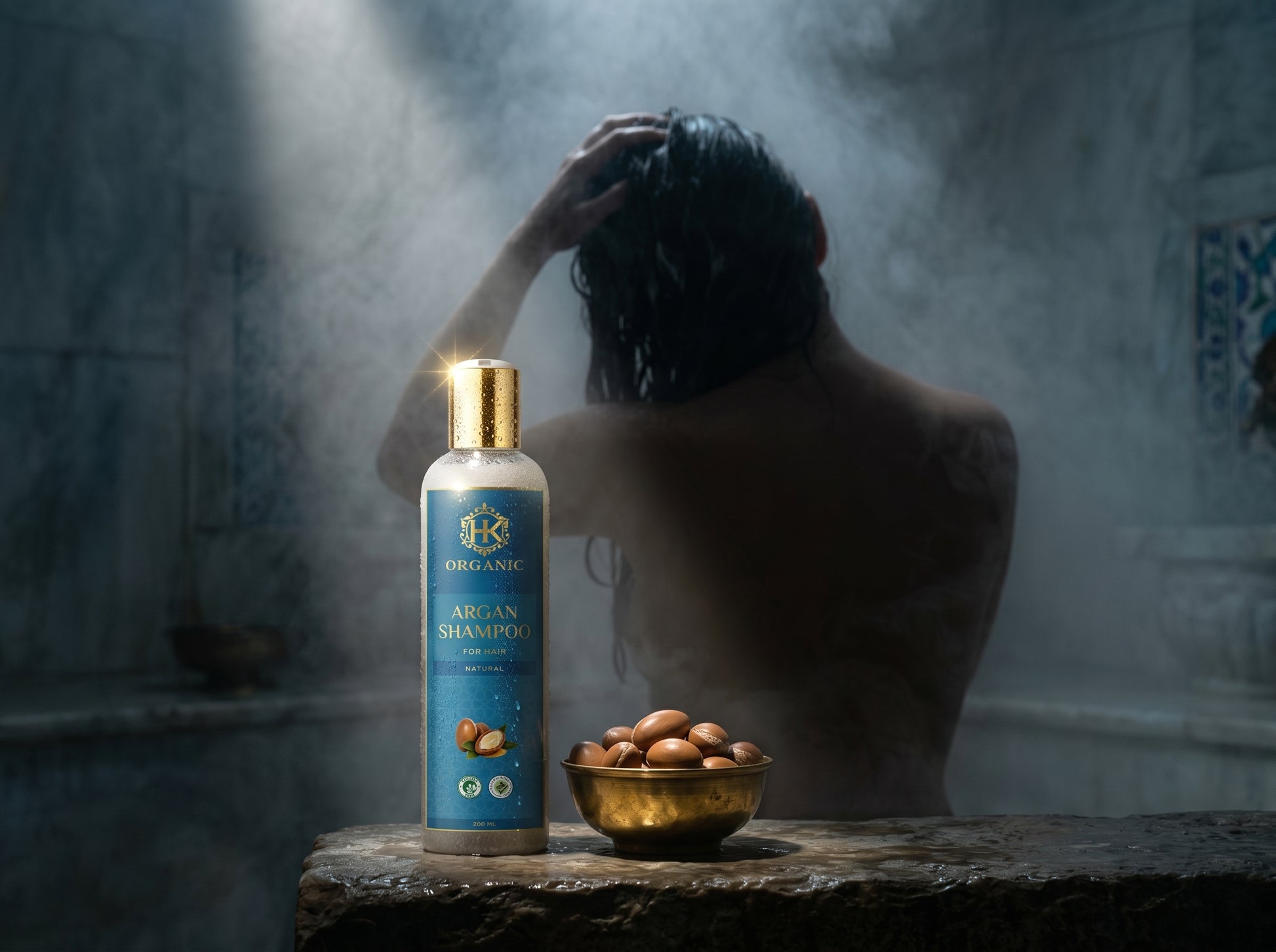 Bottle of organic African shampoo on a stone surface with a person and bowl in the background.