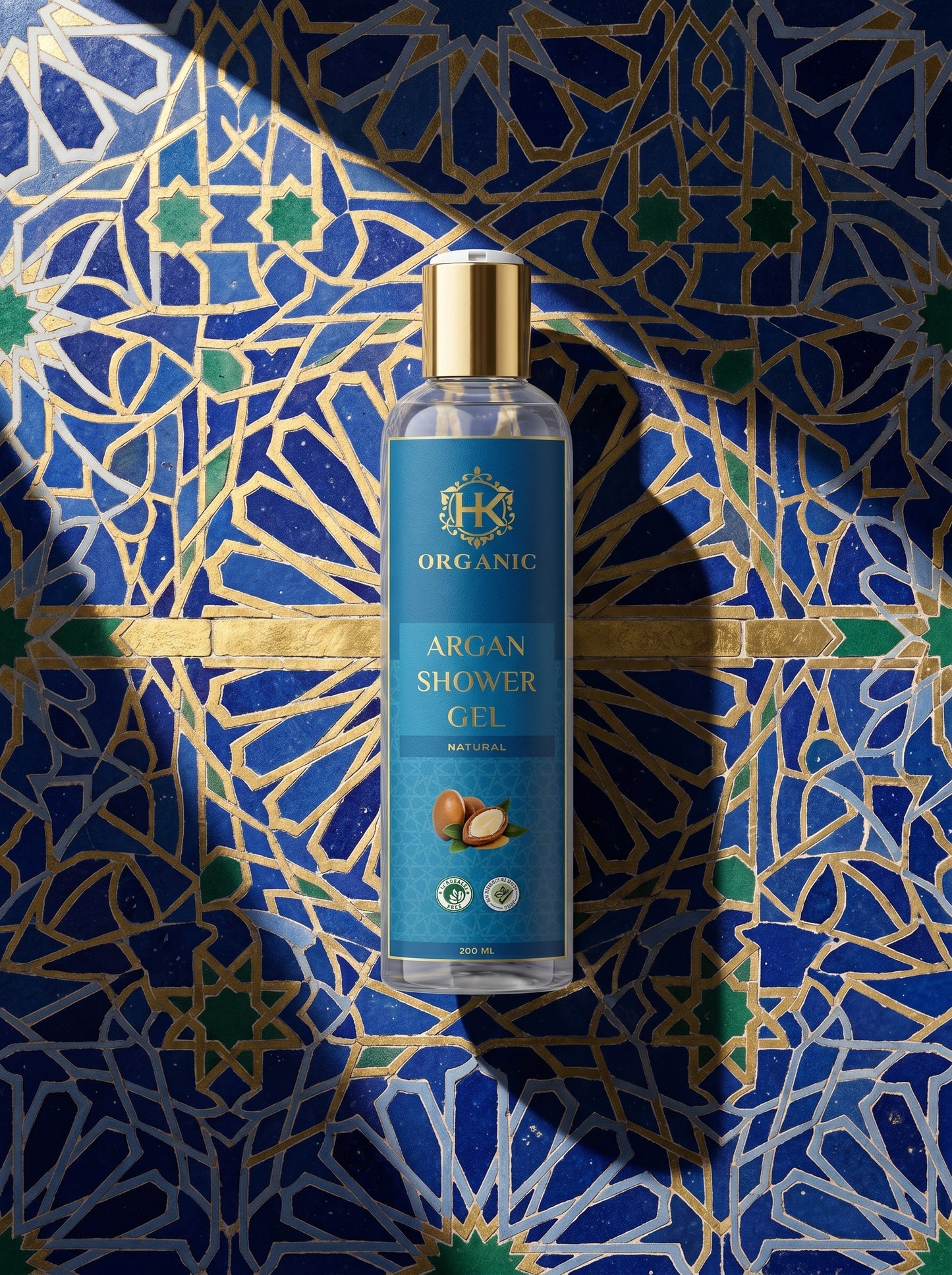 Bottle of argan shower gel on a decorative blue and gold background