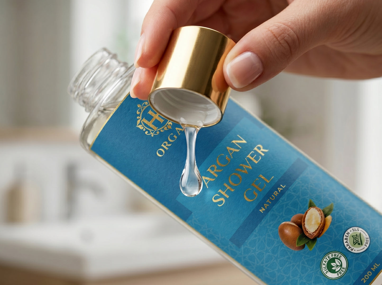 Hand holding a bottle cap of Organic Argan Shower Gel with a blue label.