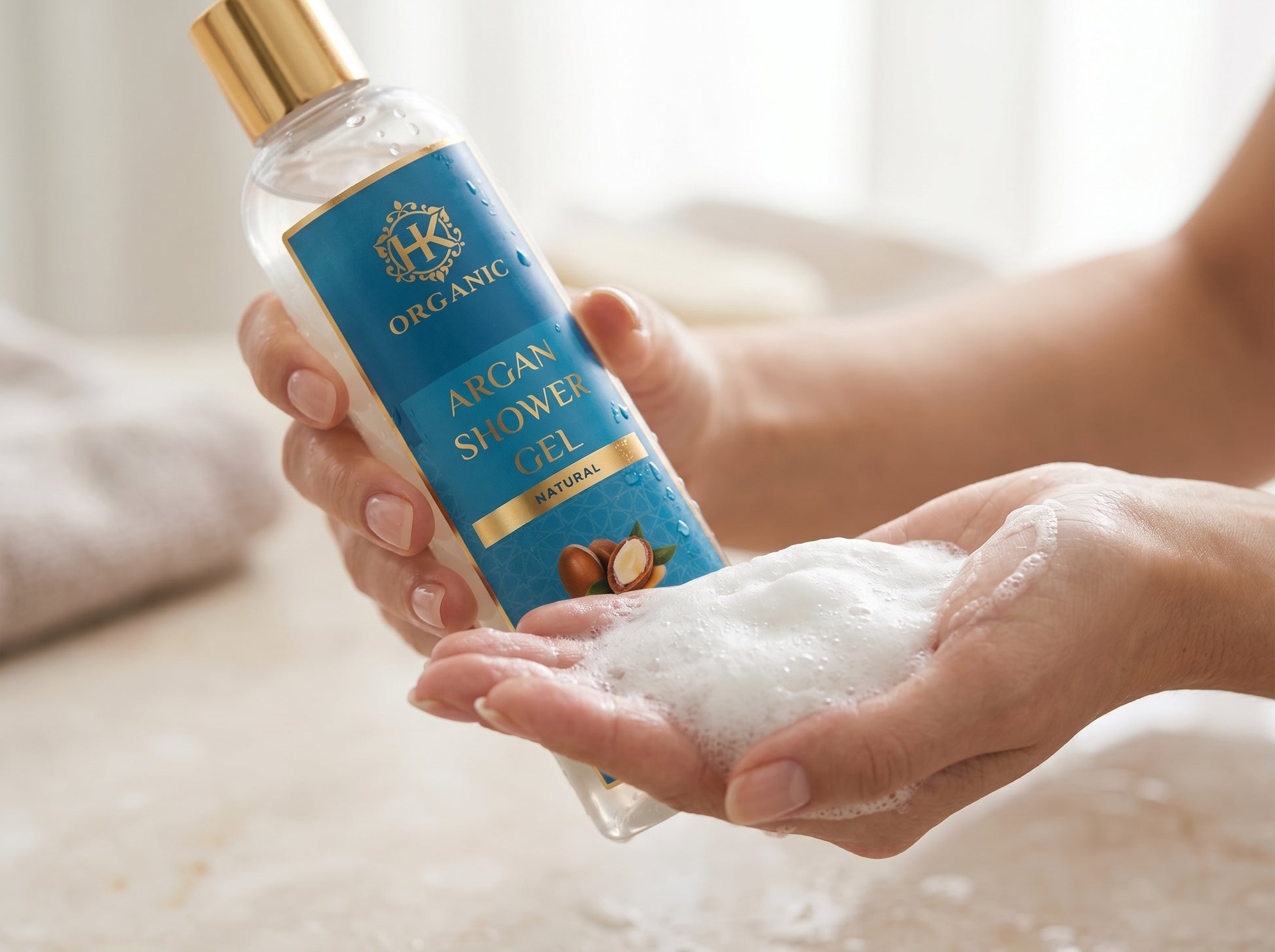Person holding a bottle of argan shower gel with foamy hands