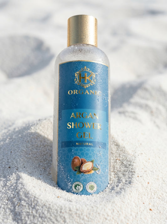 Bottle of organic argan shower gel on sand