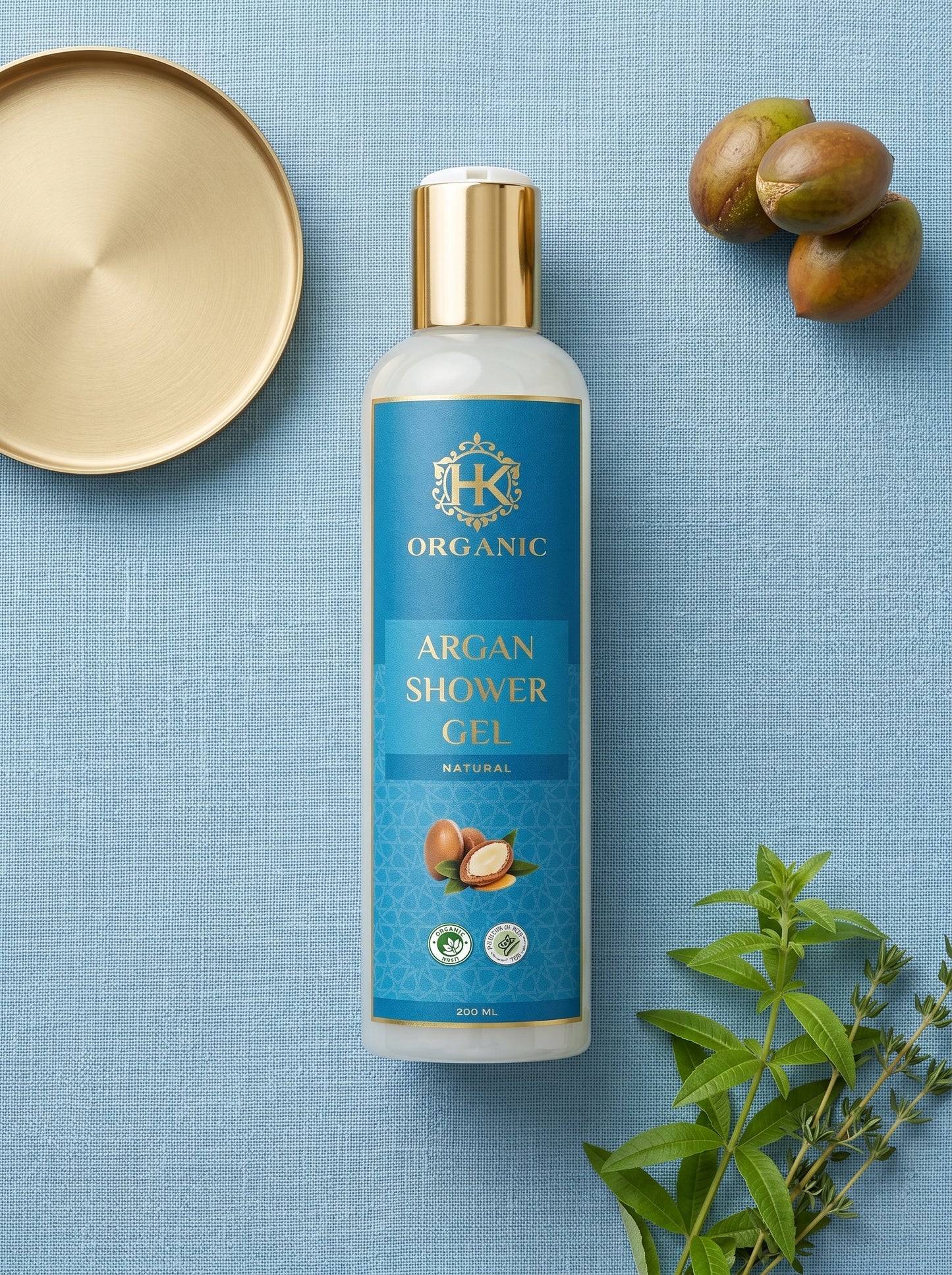 HK Organic Argan Shower Gel bottle on a blue background with nuts and leaves.