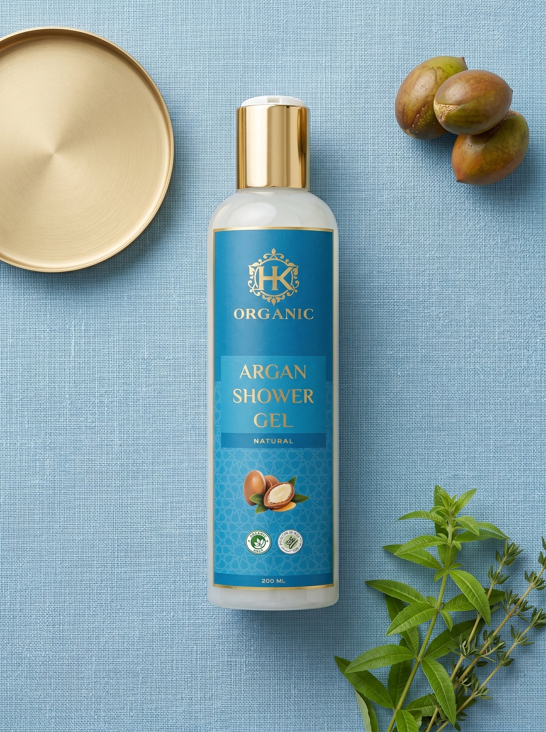 HK Organic Argan Shower Gel bottle on a blue background with nuts and leaves.