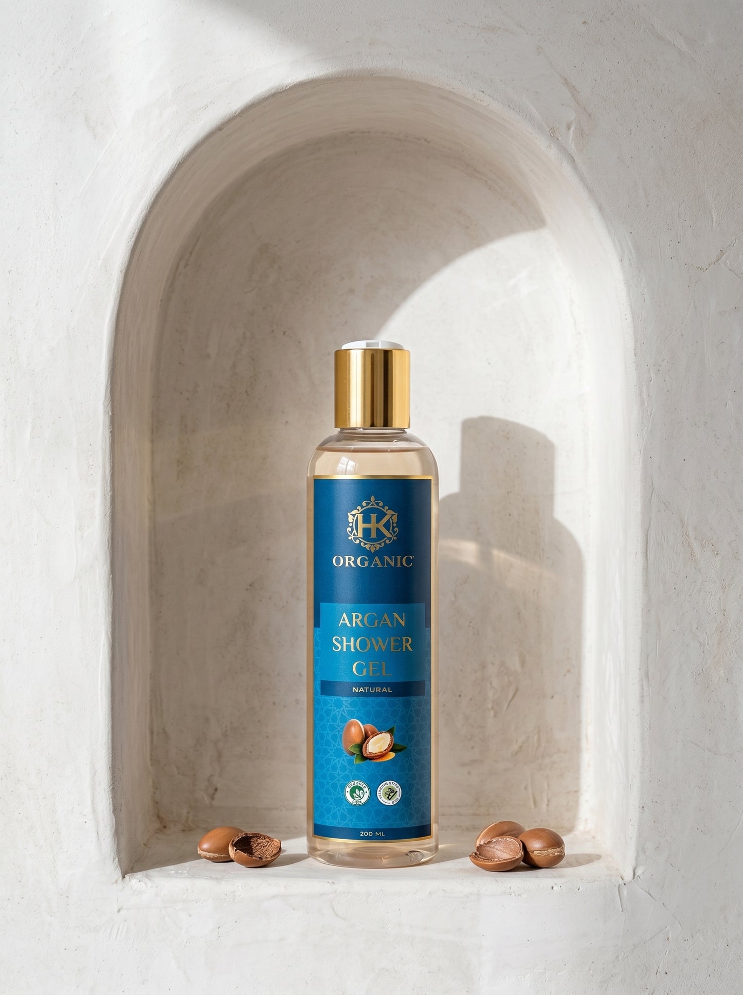 Bottle of Argan Shower Gel with blue label and gold cap on a white background