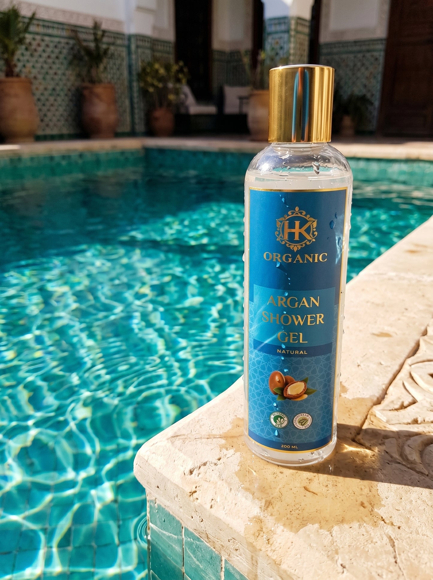 Bottle of organic argan shower gel on a ledge by a pool