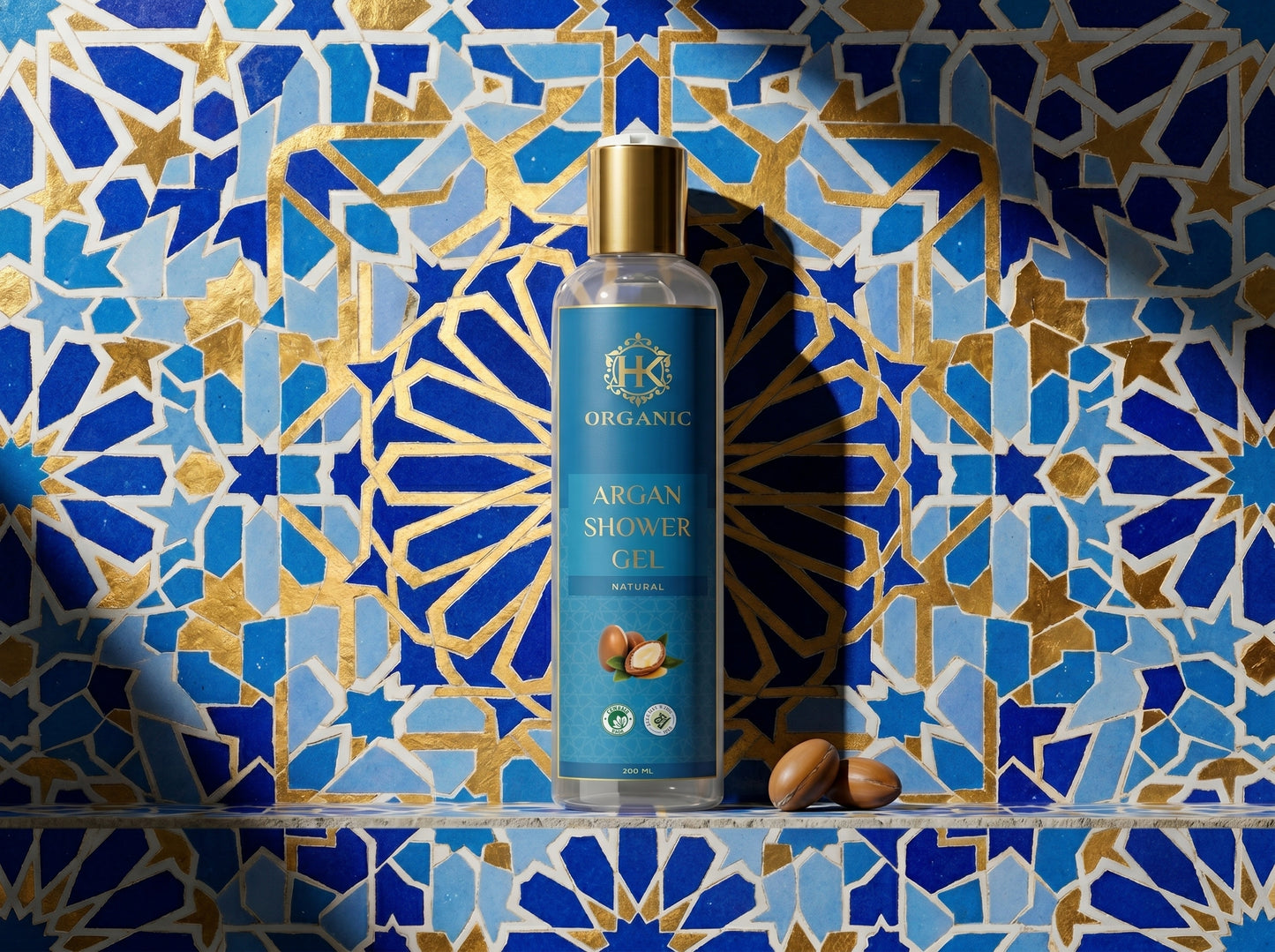 Bottle of argan shower gel against a decorative blue and gold tiled wall