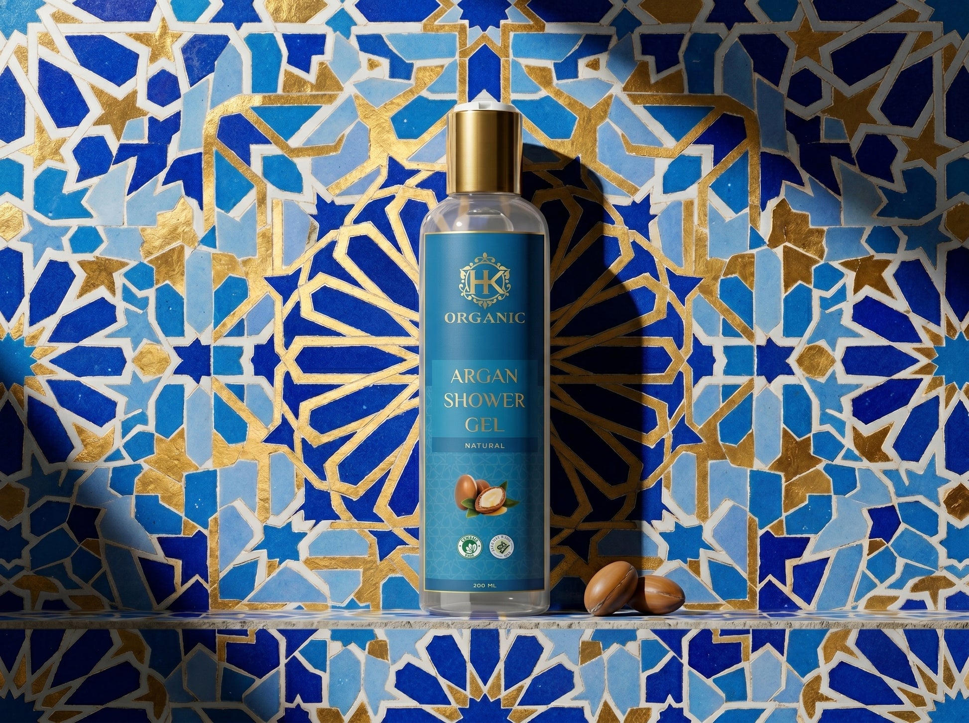 Bottle of argan shower gel against a decorative blue and gold tiled wall
