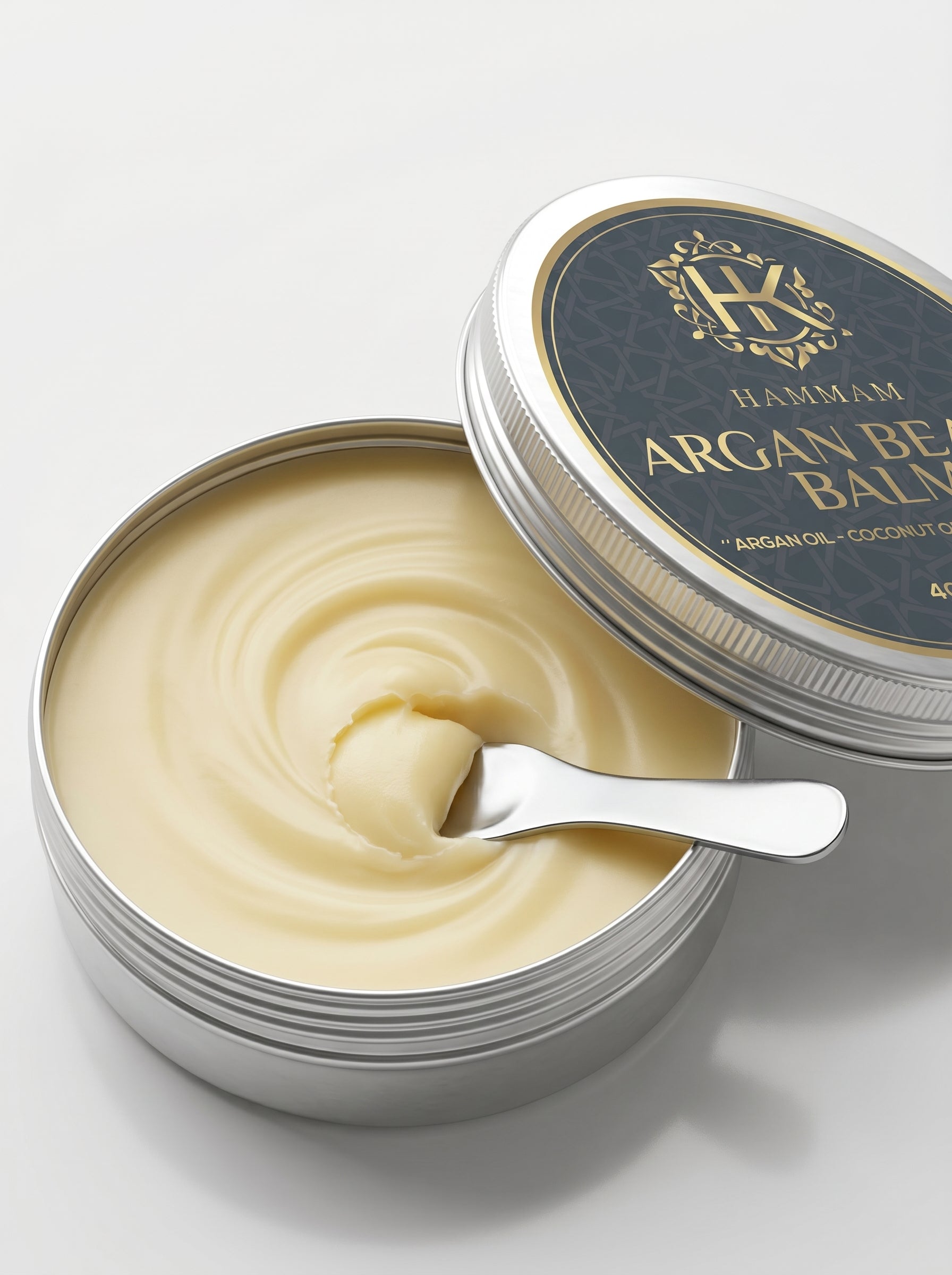 Open tin of argan balm with a spoon on a white background