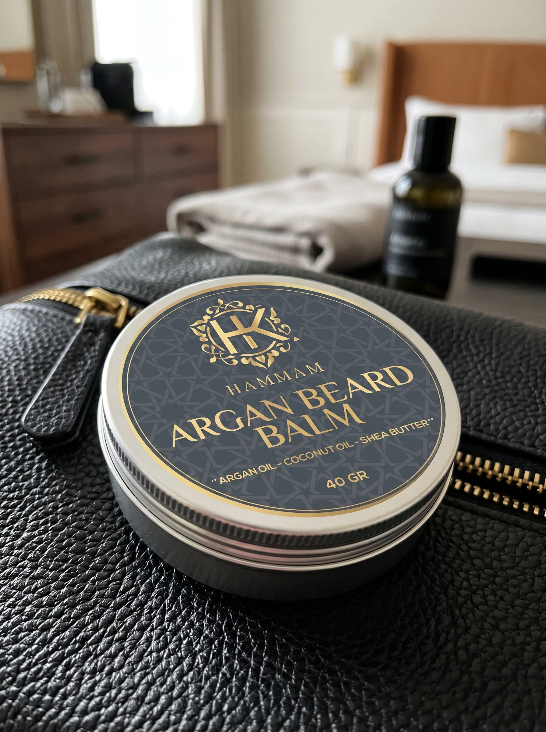 Hammam Argan Beard Balm container on a textured surface with a bedroom background