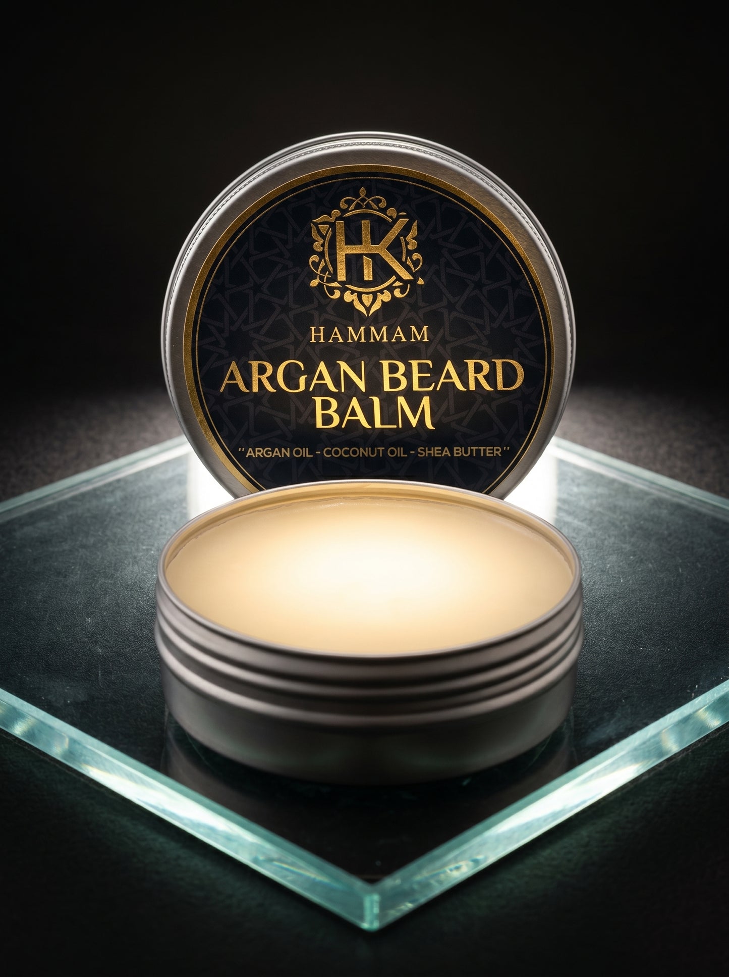 Hamam Argan Beard Balm container on a reflective surface with a dark background