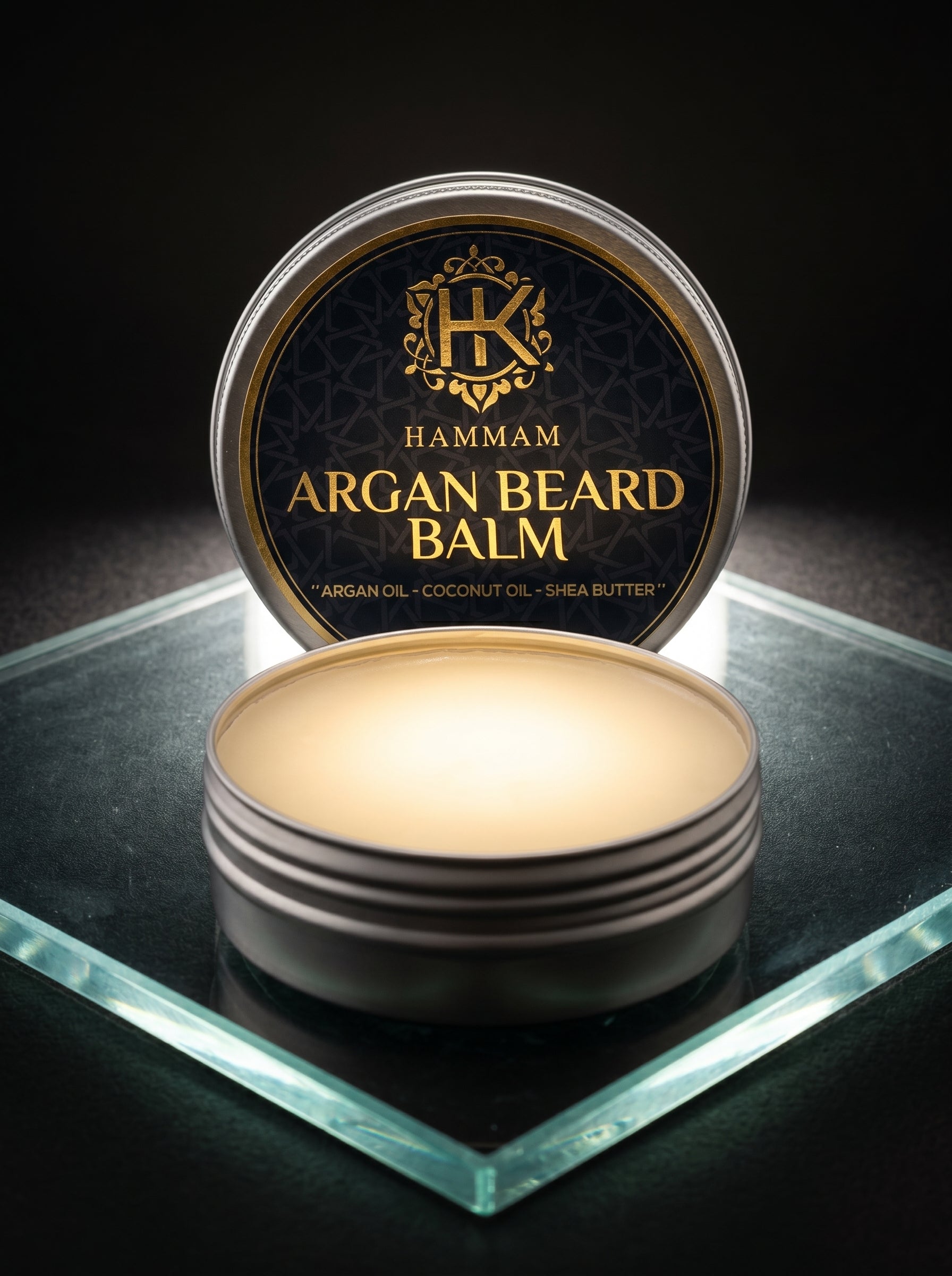 Hamam Argan Beard Balm container on a reflective surface with a dark background