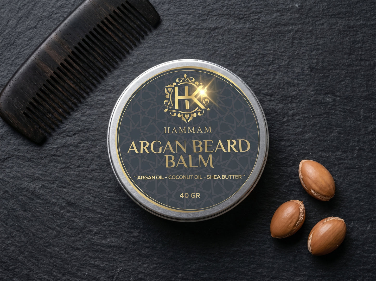 Hammam Argan Beard Balm container with a comb and argan seeds on a dark surface