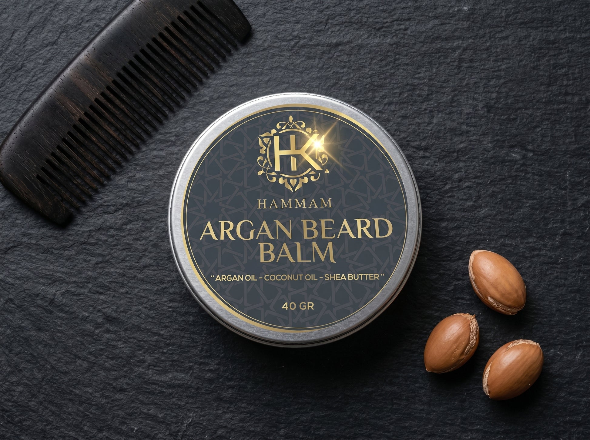 Hammam Argan Beard Balm container with a comb and argan seeds on a dark surface