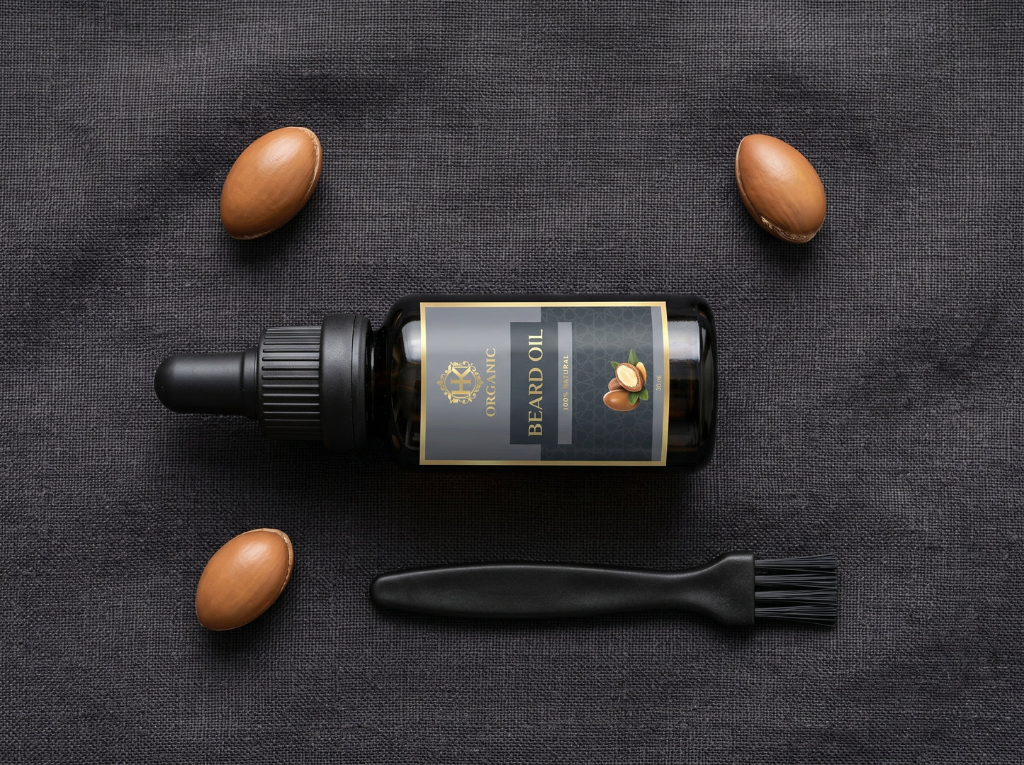 Beard oil bottle with almonds and a brush on a dark fabric background