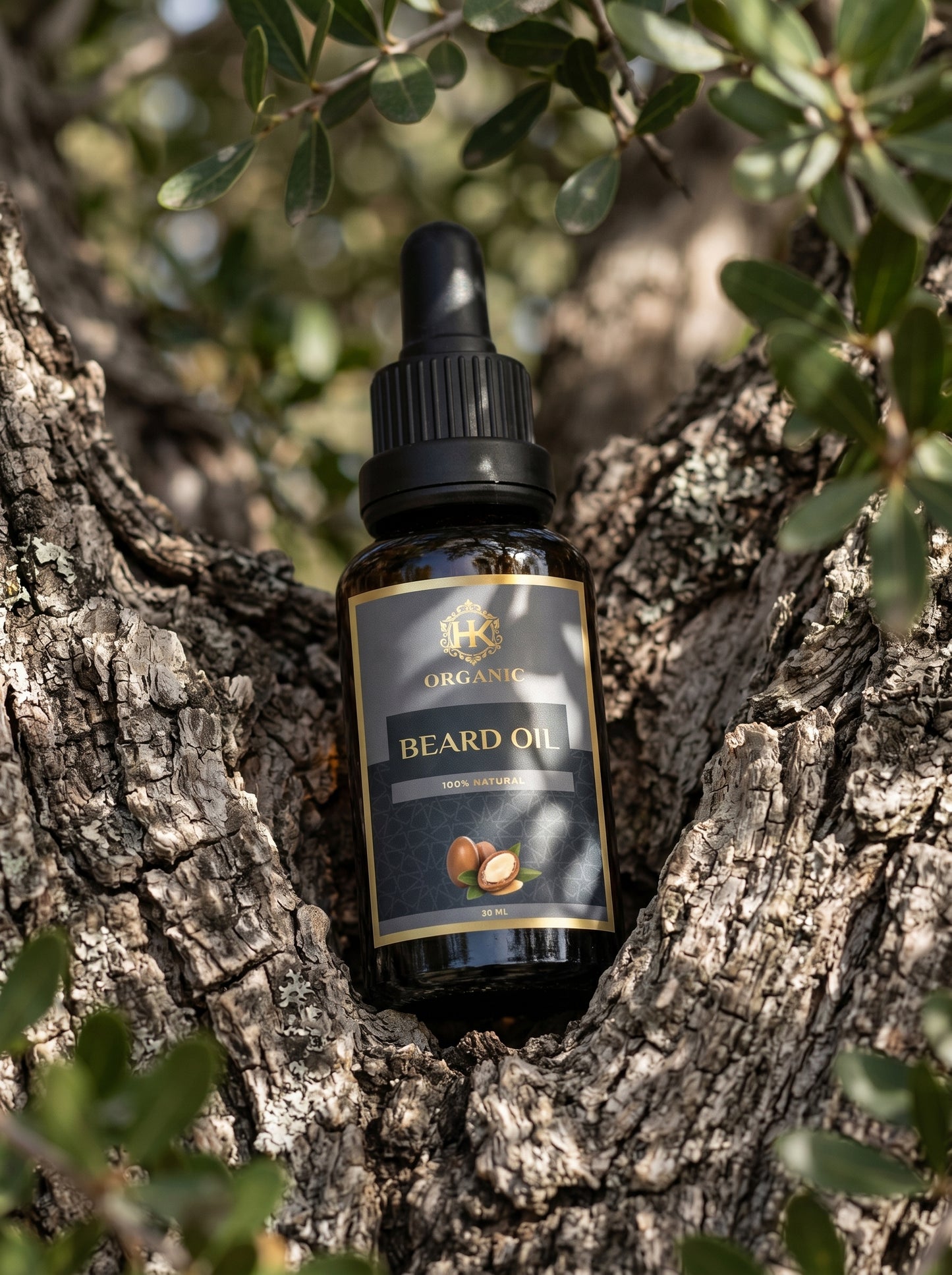 Bottle of beard oil on a tree branch with green leaves