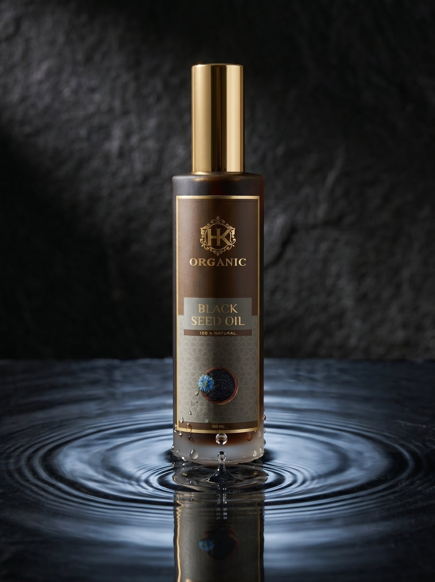Bottle of organic black seed oil with a gold cap on a reflective surface.