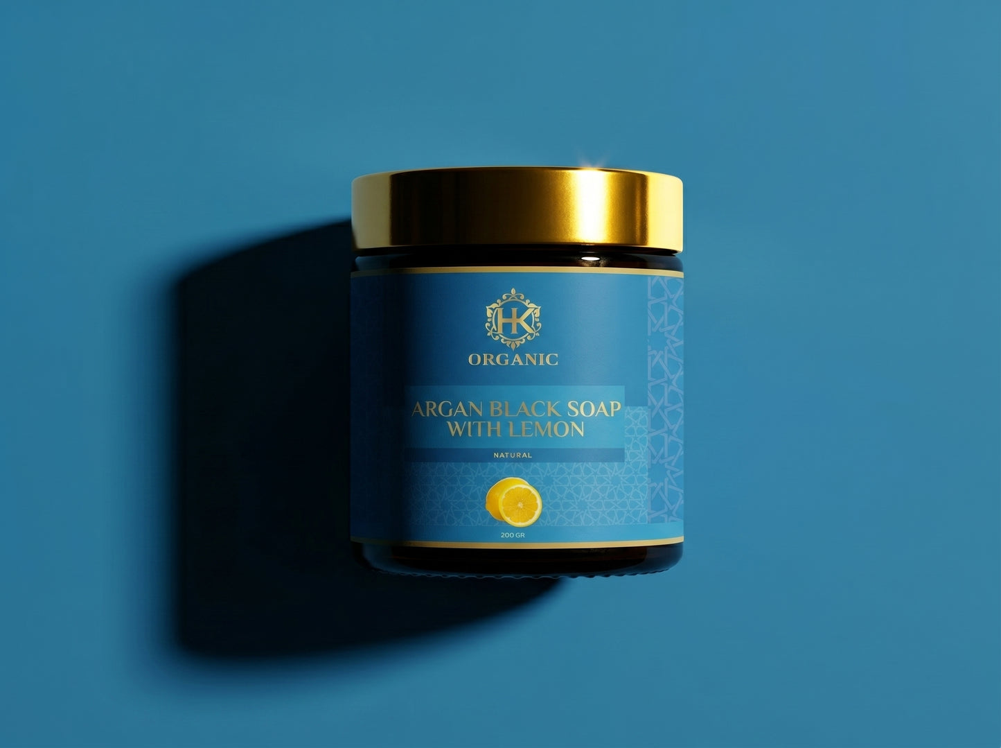 Jar of argan black soap with lemon on a blue background