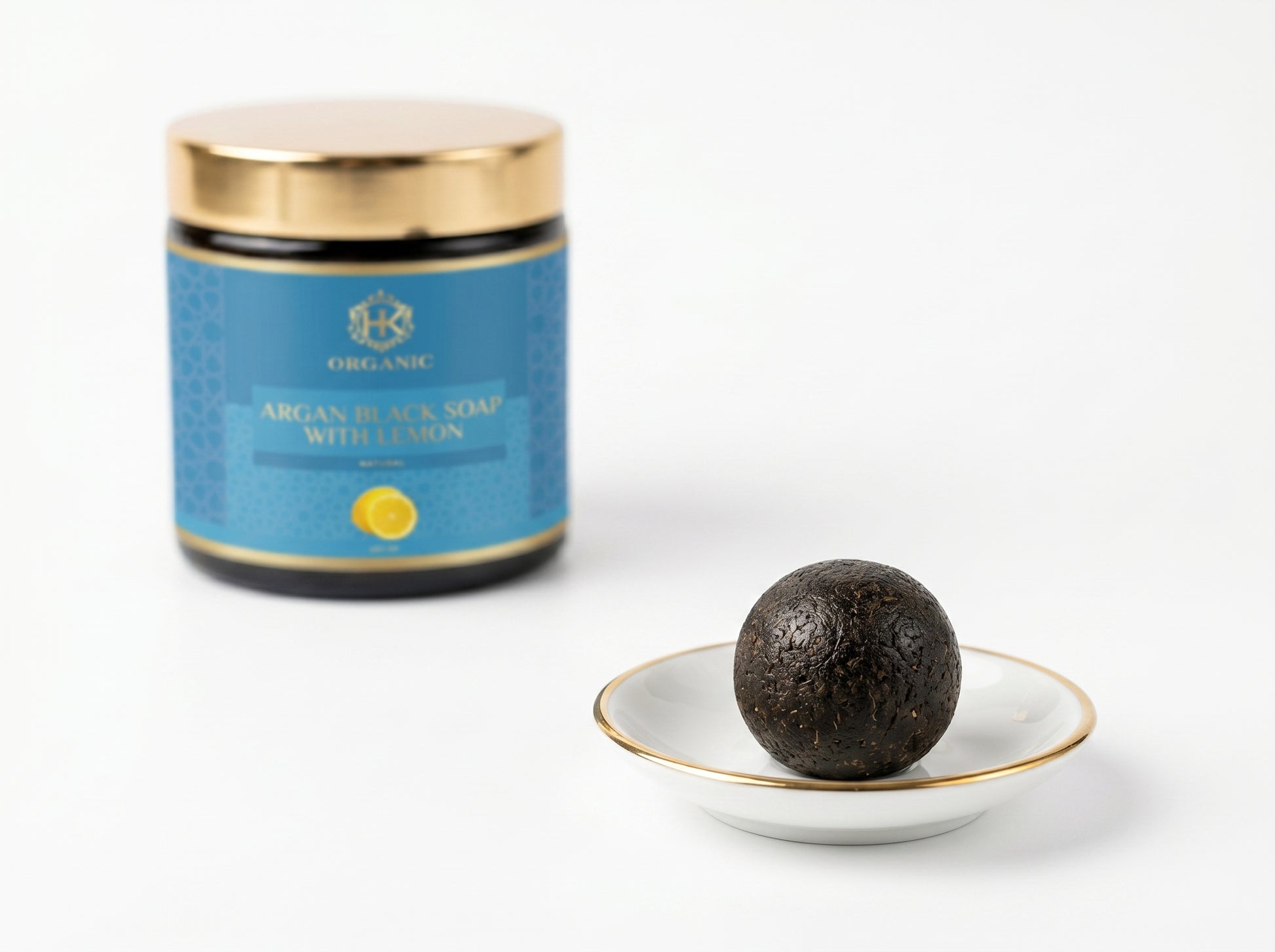 Argan black soap with a blue container on a white background