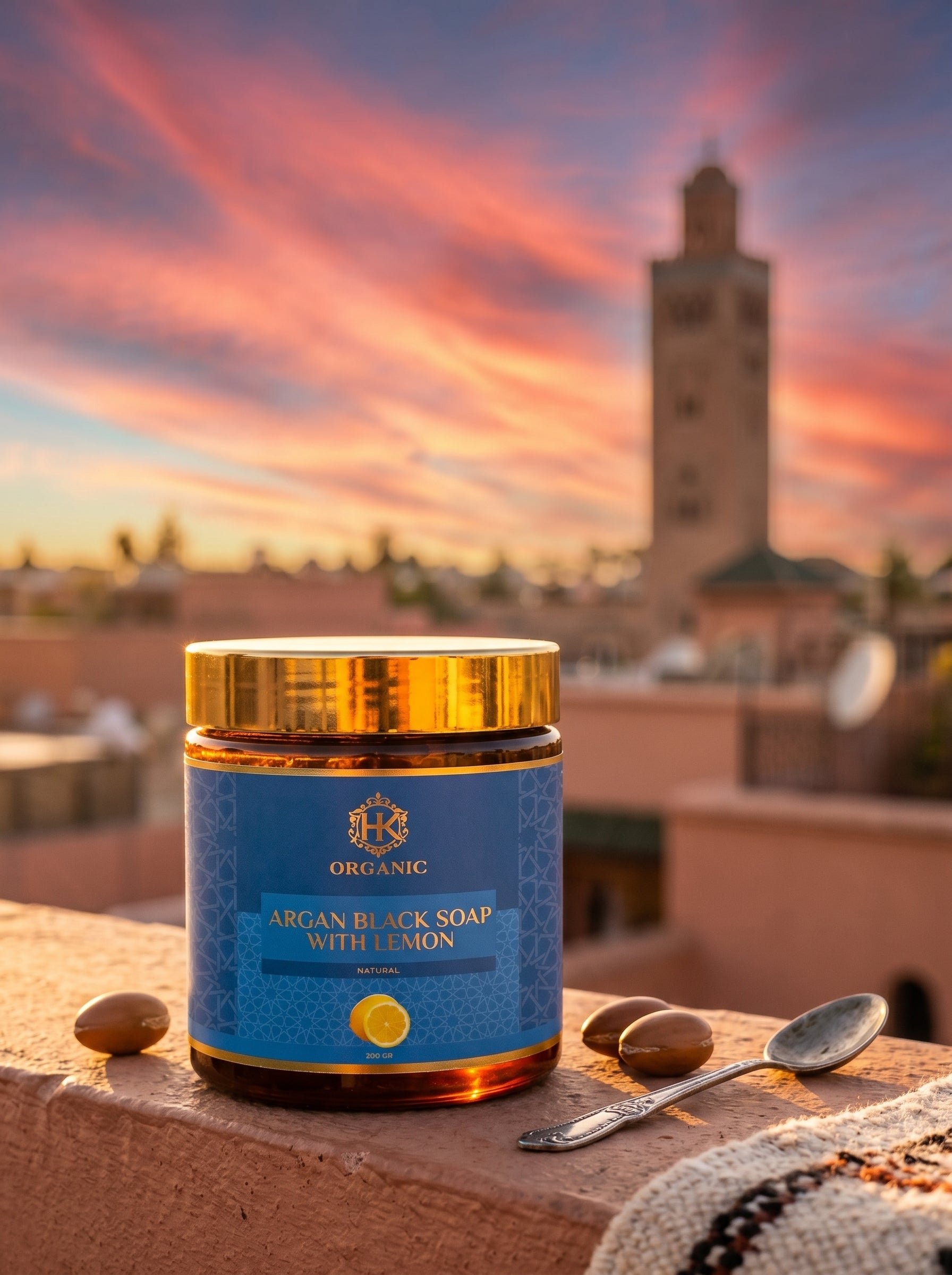 Jar of Argan Black Soap with Lemon on a rooftop with a sunset and tower in the background