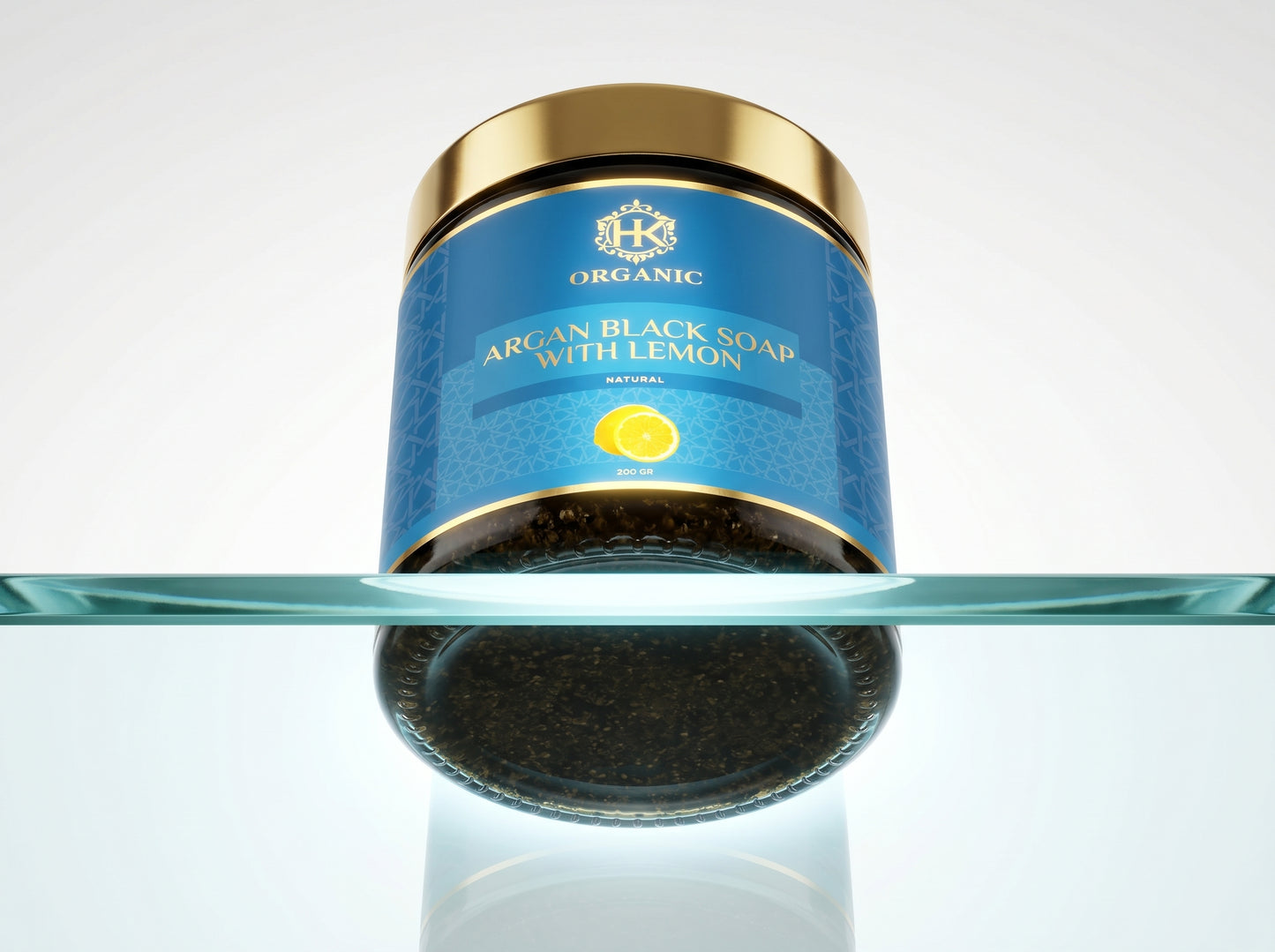 Jar of argan black soap with lemon on a reflective surface