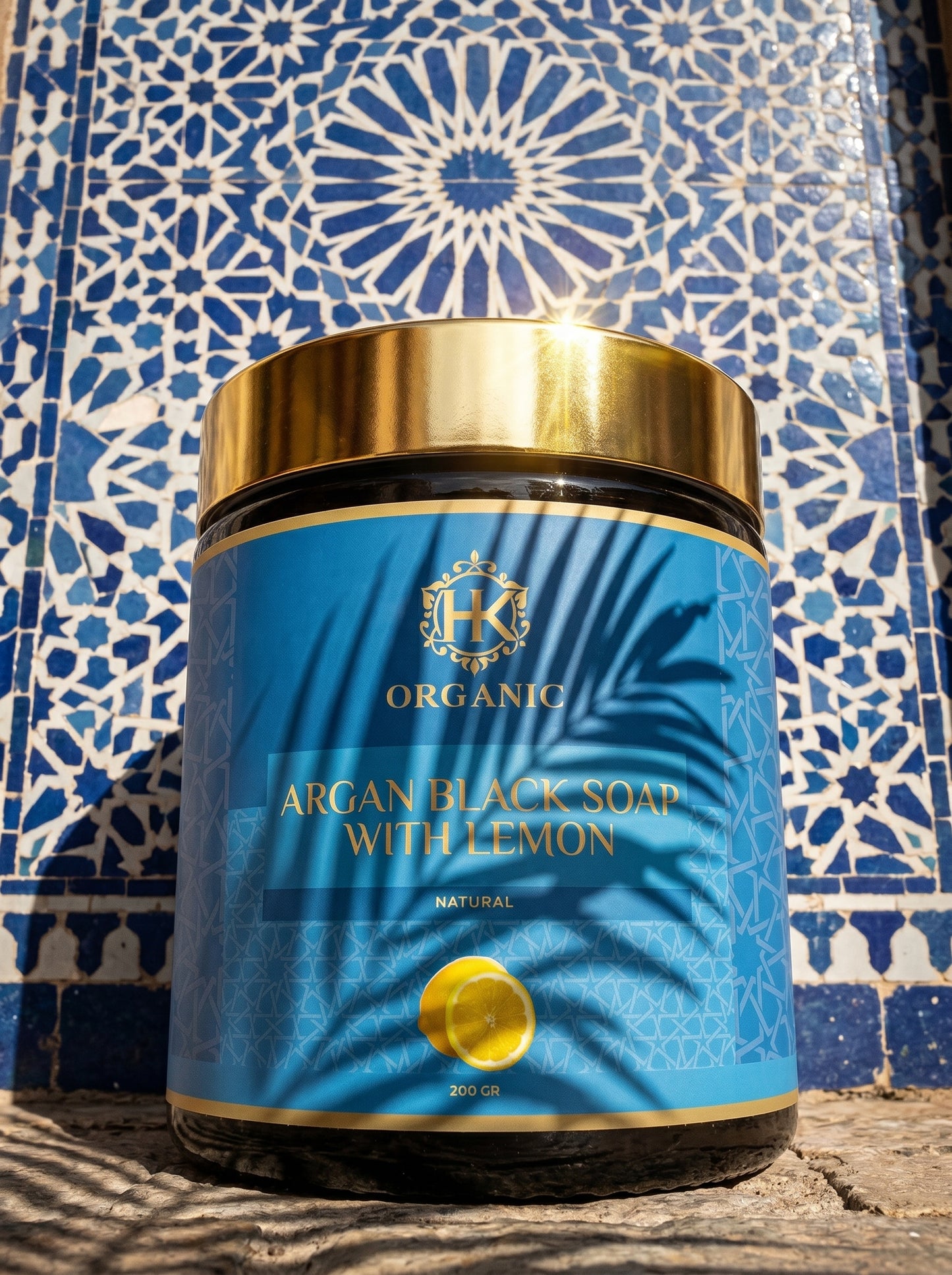 Jar of argan black soap with lemon on a blue and white patterned tile background