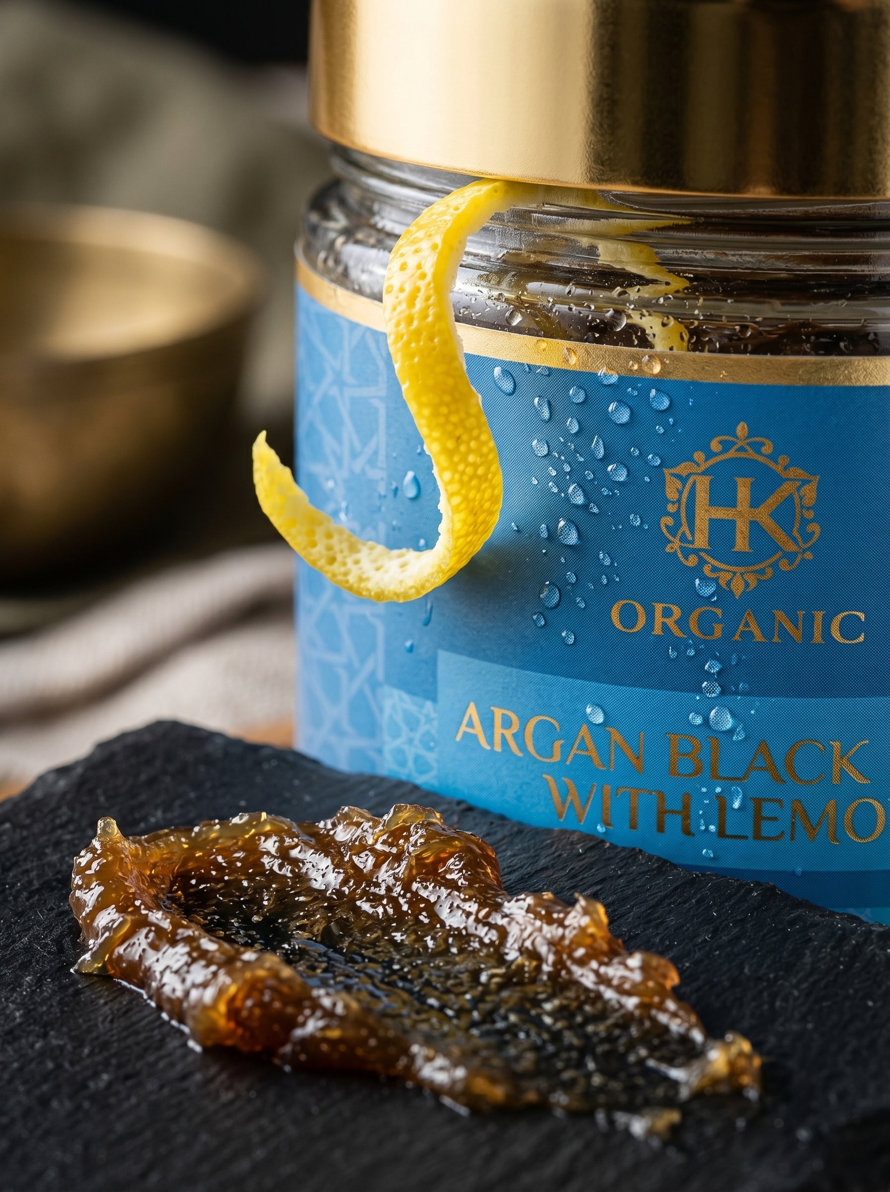 Jar of HK Organic Argan Black with Lemon on a dark surface