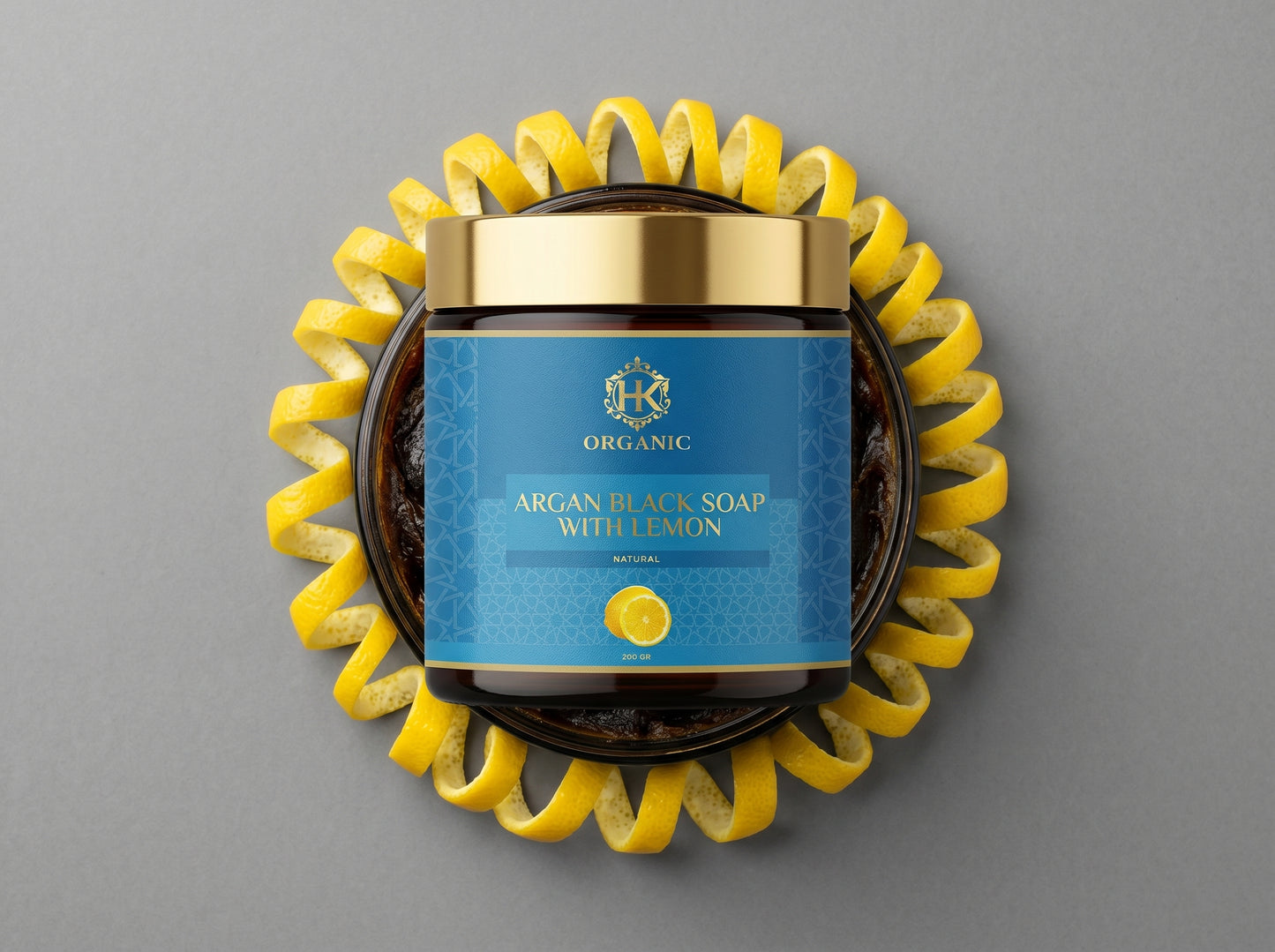 Jar of argan black soap with lemon on a gray background