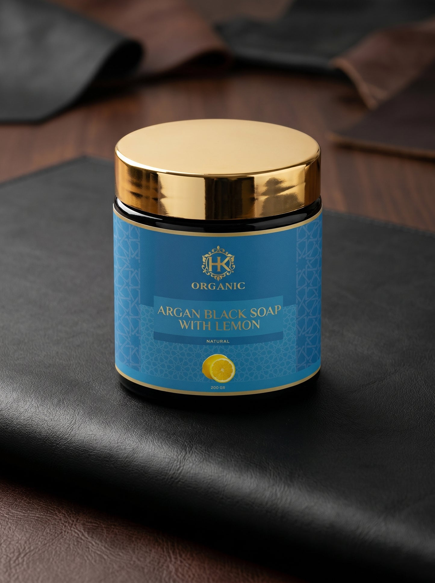 Jar of argan black soap with lemon on a dark surface