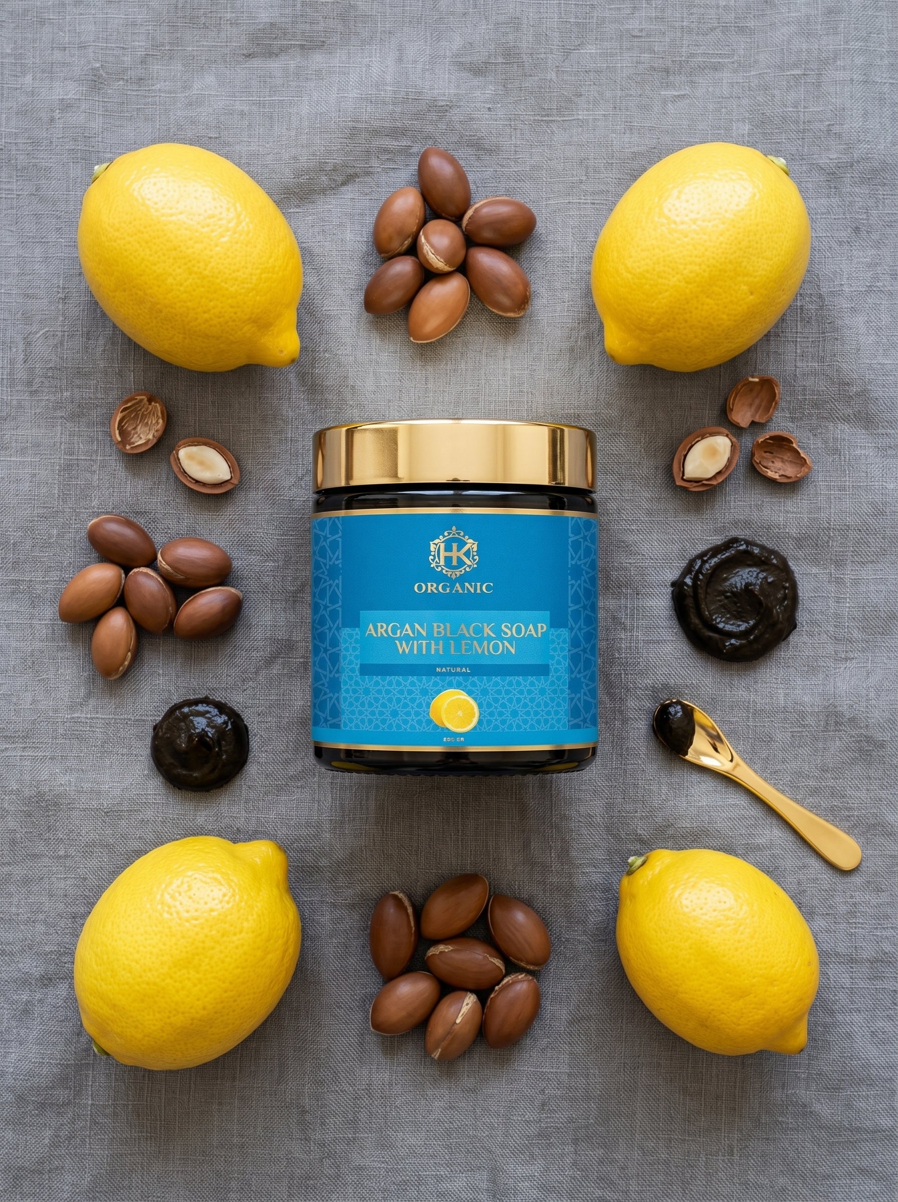 Argan black soap with lemons and nuts on a gray surface