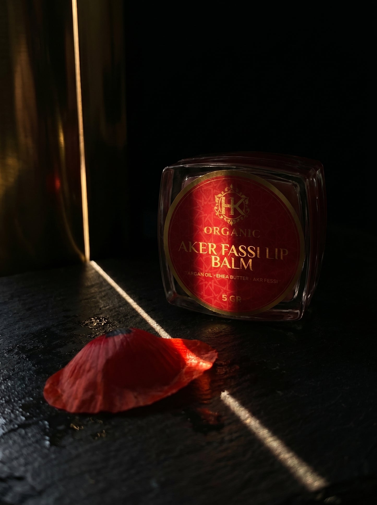 Lip balm with red label on a dark surface
